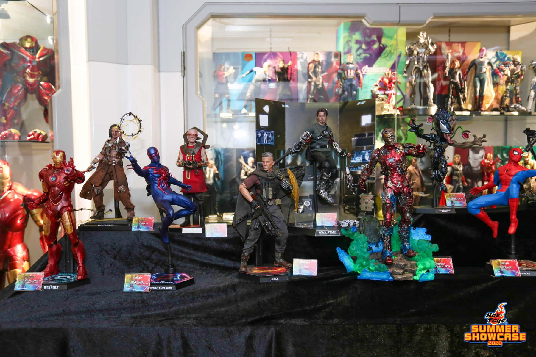 toys 桌布 壁紙 — 在明亮的室內燈光下，玻璃陳列櫃內黑色天鵝絨支架上展示的精緻超級英雄動作人偶。