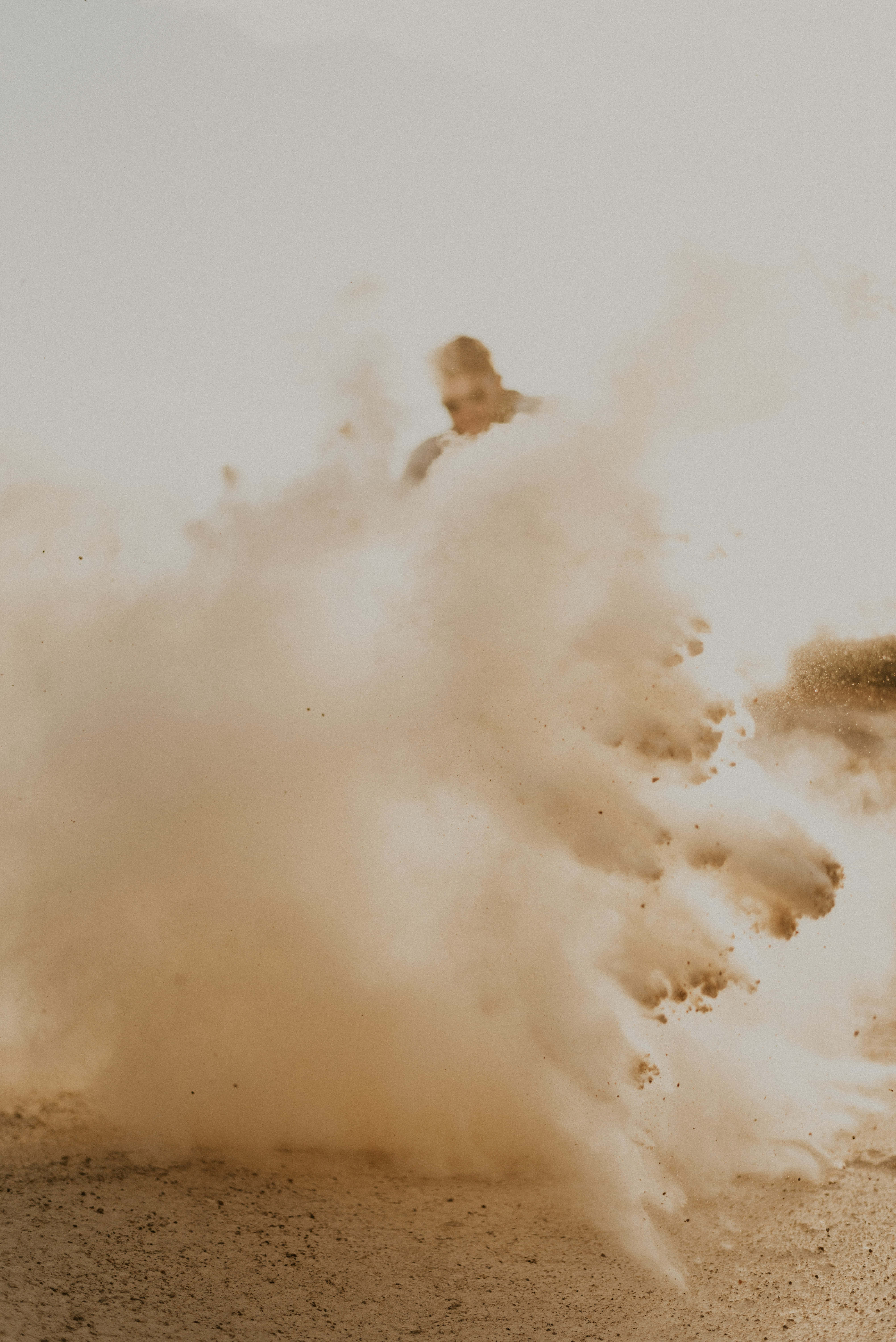 Dust 桌布 壁紙 — 在明亮的日光下，一個人從沙漠景觀中的巨大沙雲中出現。