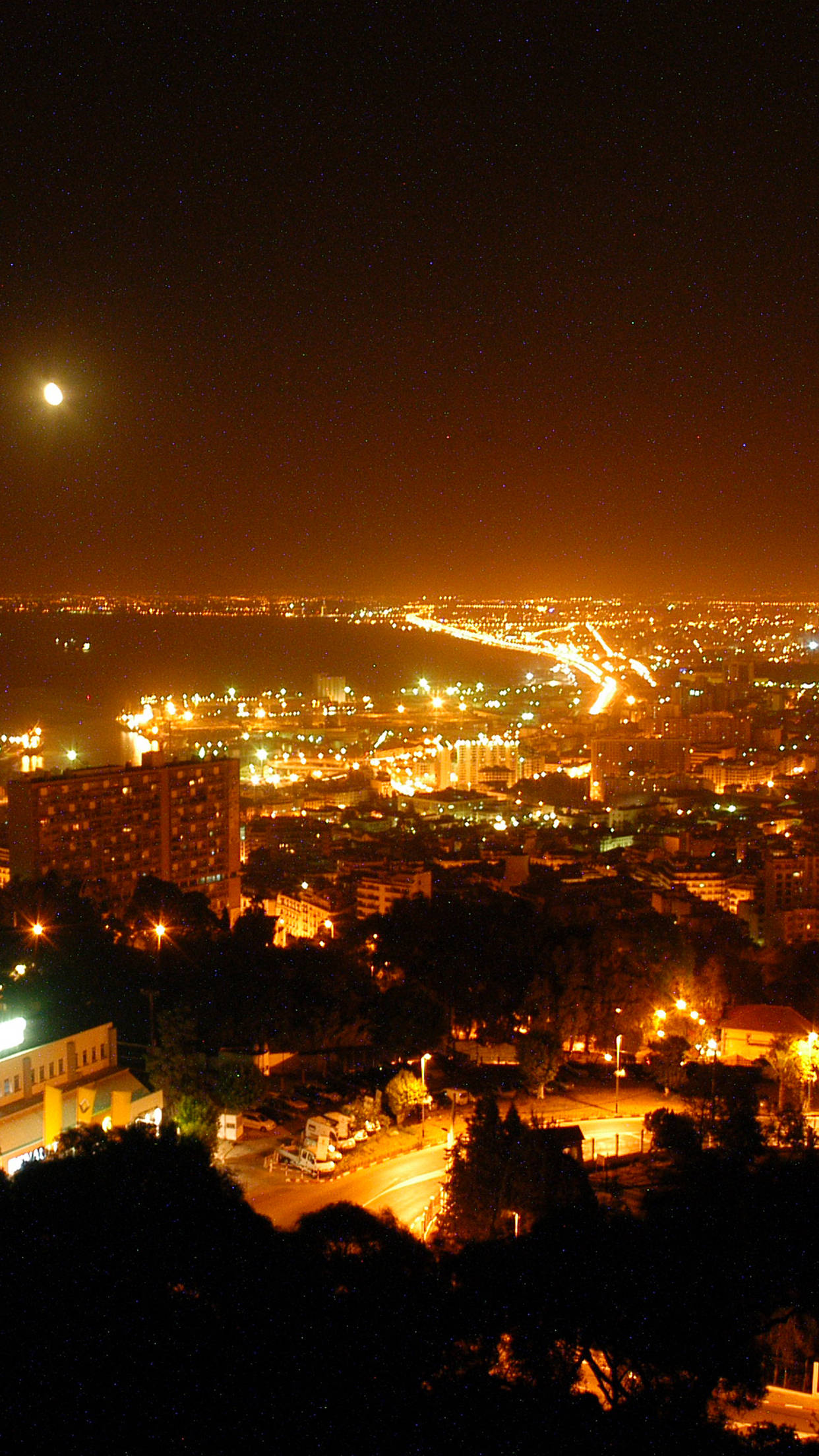 Algeria 桌布 壁紙 — 在明亮的月亮和星空下，沿海城市全景夜景，溫暖的燈光閃爍。