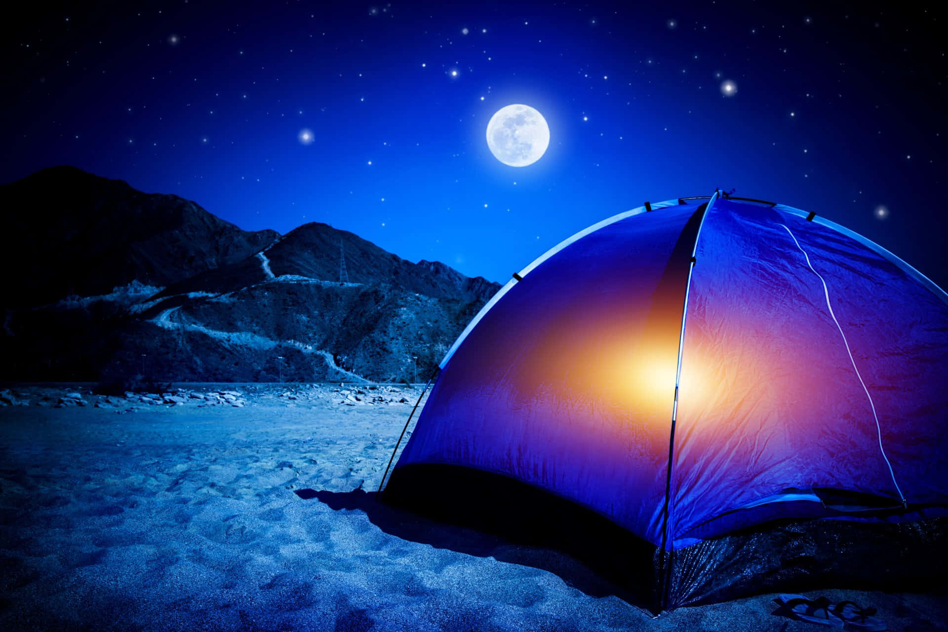 Camping 桌布 壁紙 — 在明亮的月亮和星空下，雪地上發光的藍色帳篷，背景是黑暗的山脈。