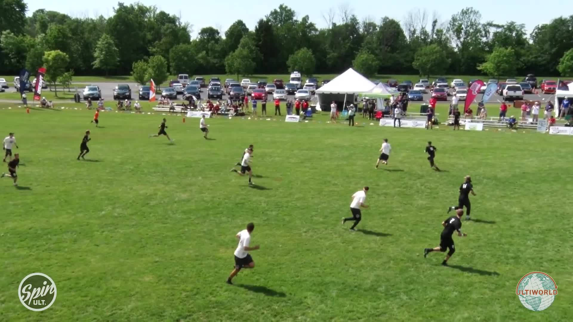 Ultimate Frisbee 桌布 壁紙 — 在明亮的白天天空下，玩家在終極飛盤比賽中衝過充滿活力的綠色場地。