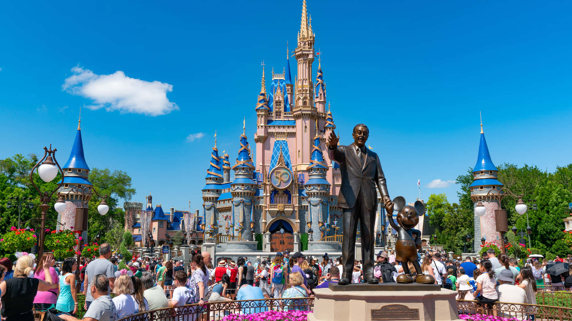 1920x1080 Disney 桌布 壁紙 — 在明亮的藍天下，一朵白雲飄浮，熙攘的人群聚集在灰姑娘城堡前。