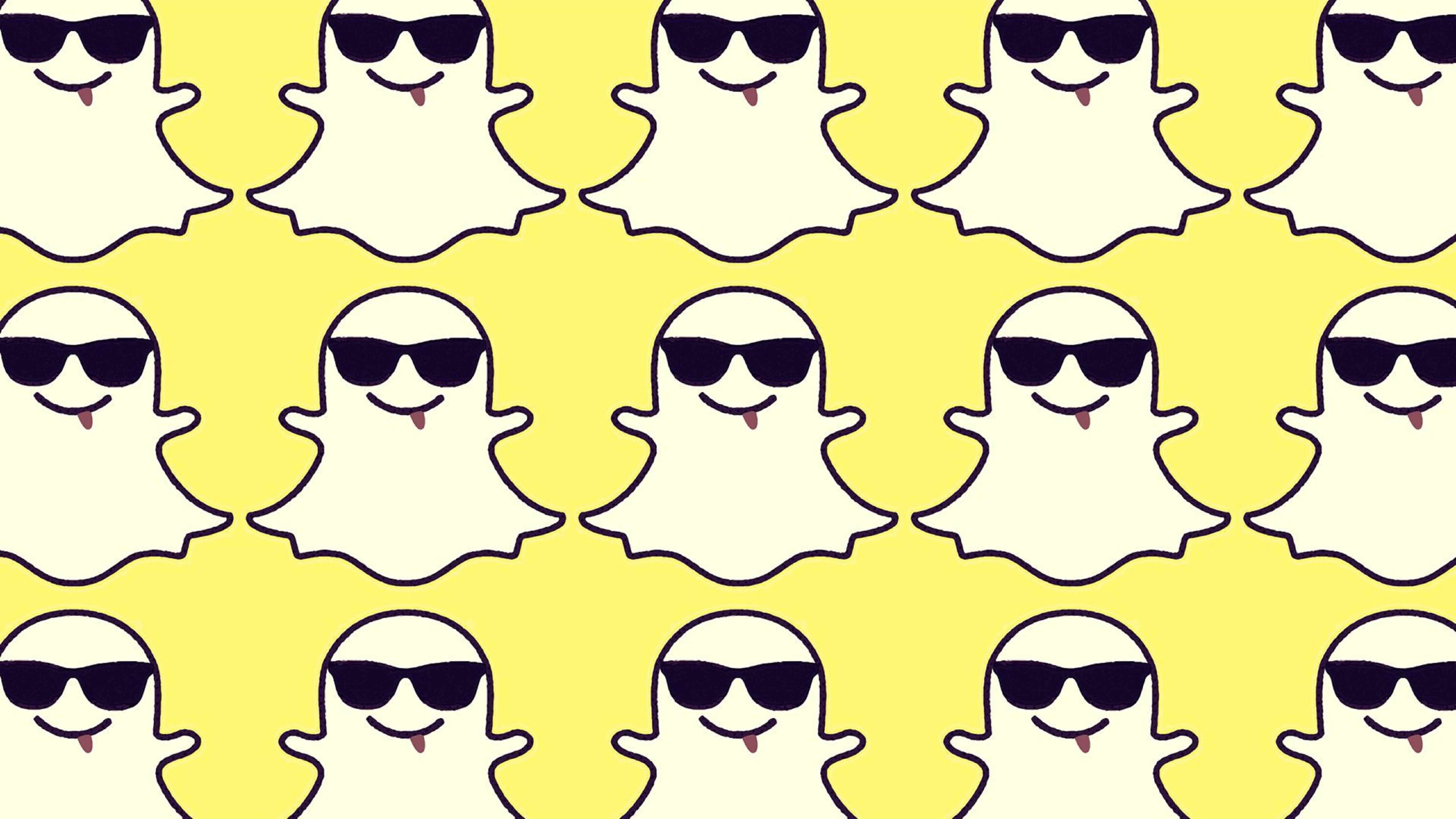Snapchat 桌布 壁紙 — 在明亮的黃色背景上重複出現的卡通鬼魂，戴著黑色太陽眼鏡和粉紅色舌頭。