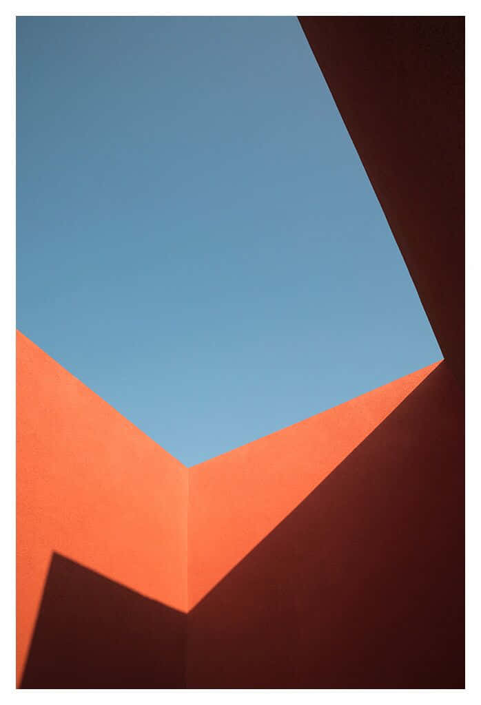 Minimalist Photography 桌布 壁紙 — 在明亮陽光下，由溫暖橙色和冷藍色組成的銳利角平面幾何抽象構圖。