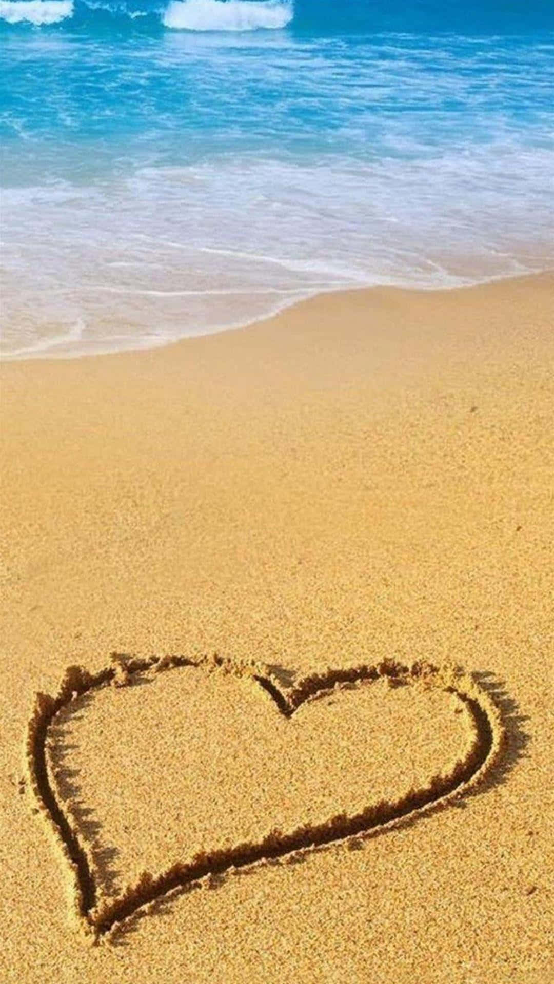 Yellow Beach 桌布 壁紙 — 在明媚陽光下，溫柔的海浪拍打著海岸線，濕沙上畫著一顆心。