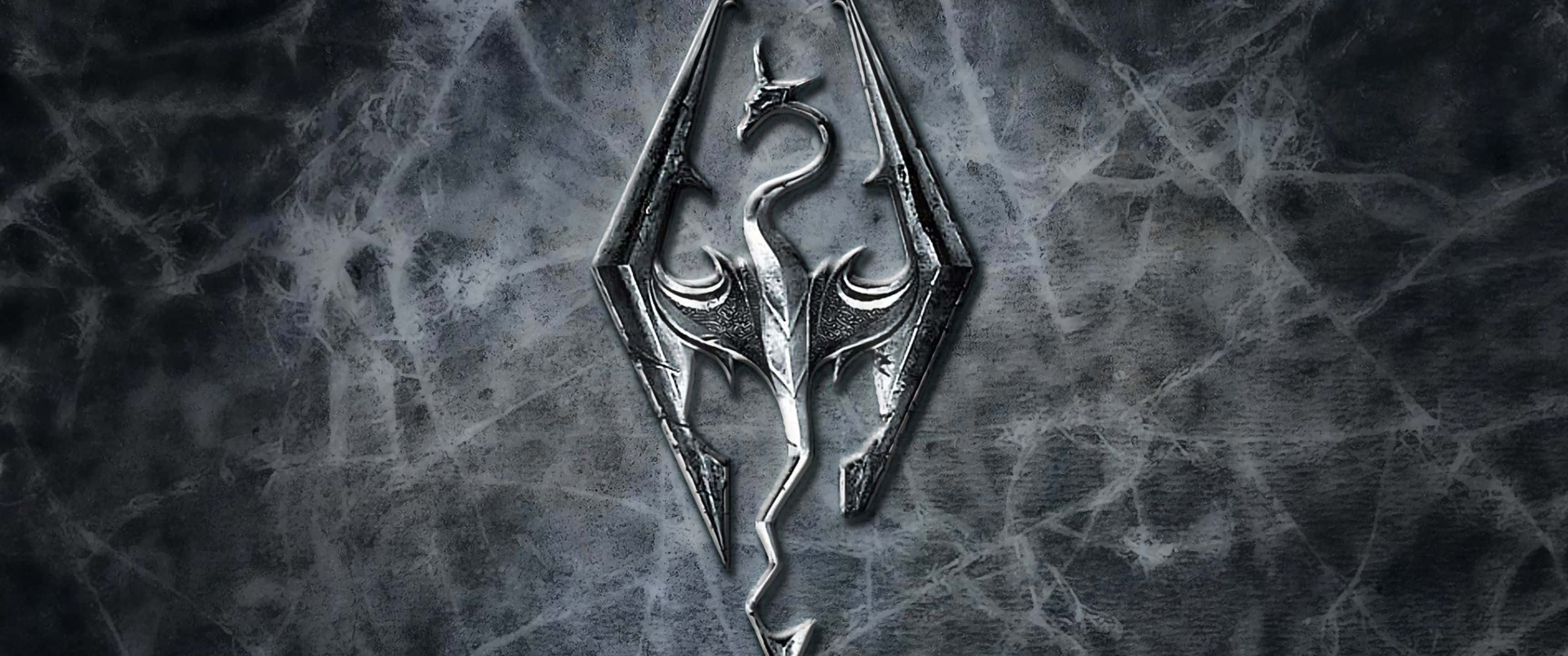 3440x1440p The Elder Scrolls V Skyrim 桌布 壁紙 — 在昏暗燈光下，一個金屬龍紋章張開翅膀蝕刻在裂開的石頭表面上。