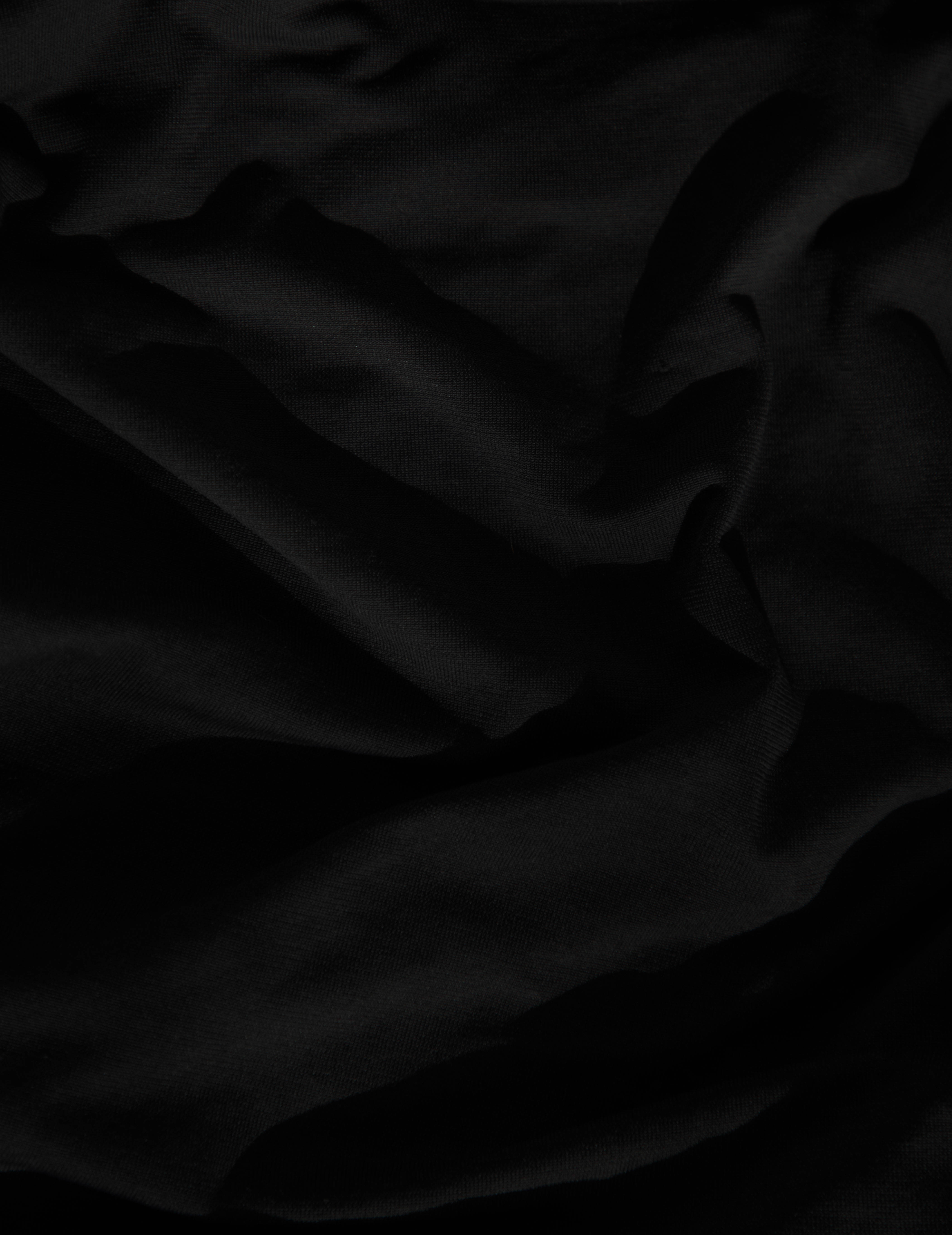 Black Page 桌布 壁紙 — 在昏暗燈光下，帶有柔軟皺褶和細膩質感的奢華黑色布料特寫。