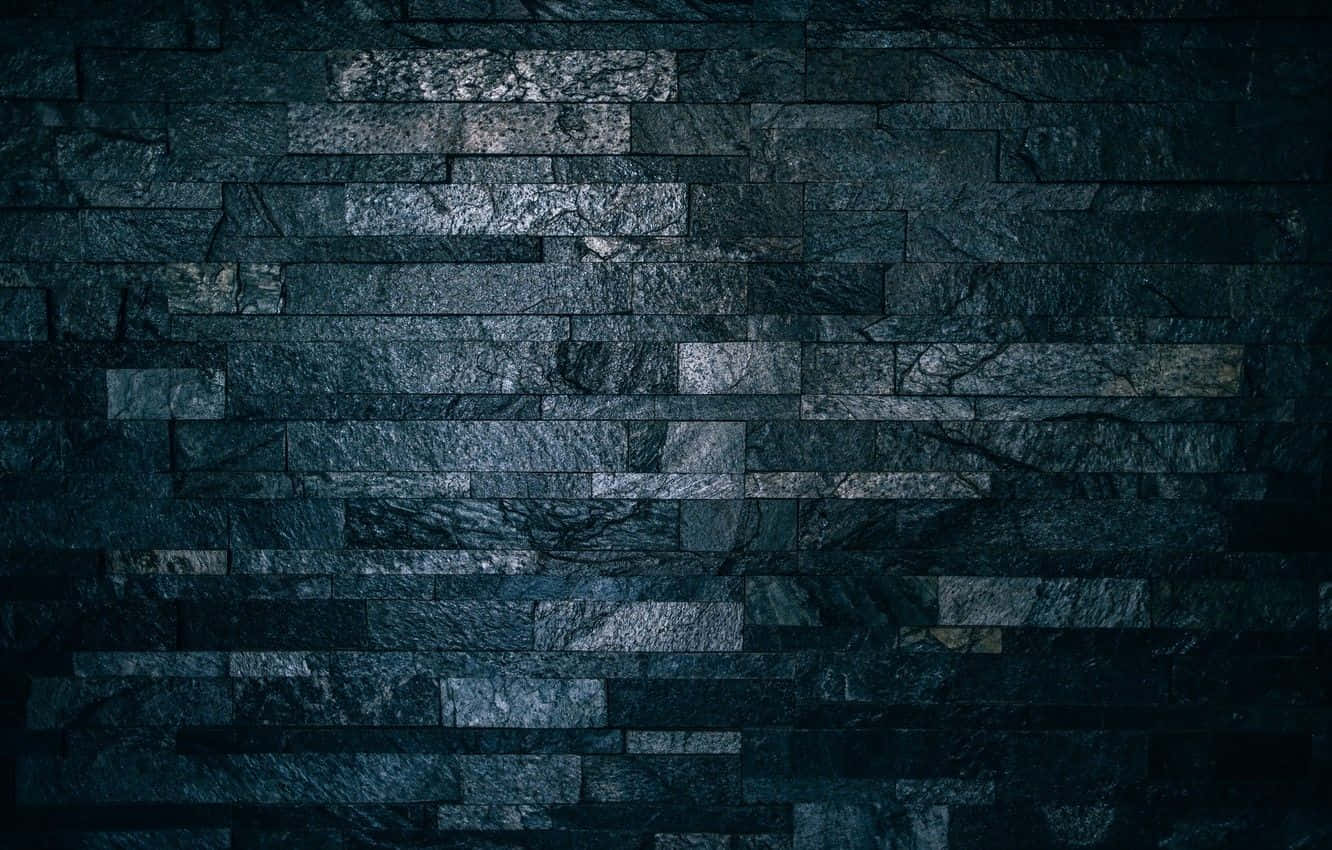 Dark Wall 桌布 壁紙 — 在昏暗燈光下，深藍色和灰色色調的層疊石板磚構成的深色紋理石牆。