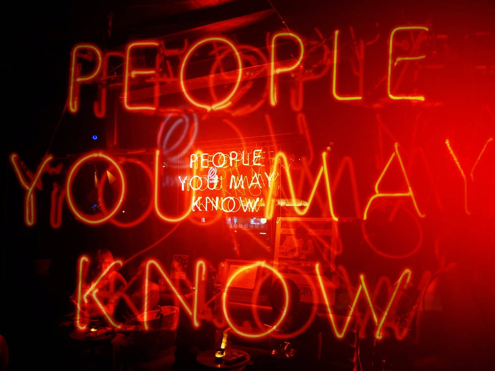 Quote 桌布 壁紙 — 在昏暗的酒吧中，一個發光的紅色霓虹燈牌寫著「PEOPLE YOU MAY KNOW」，帶有反射和塗鴉。