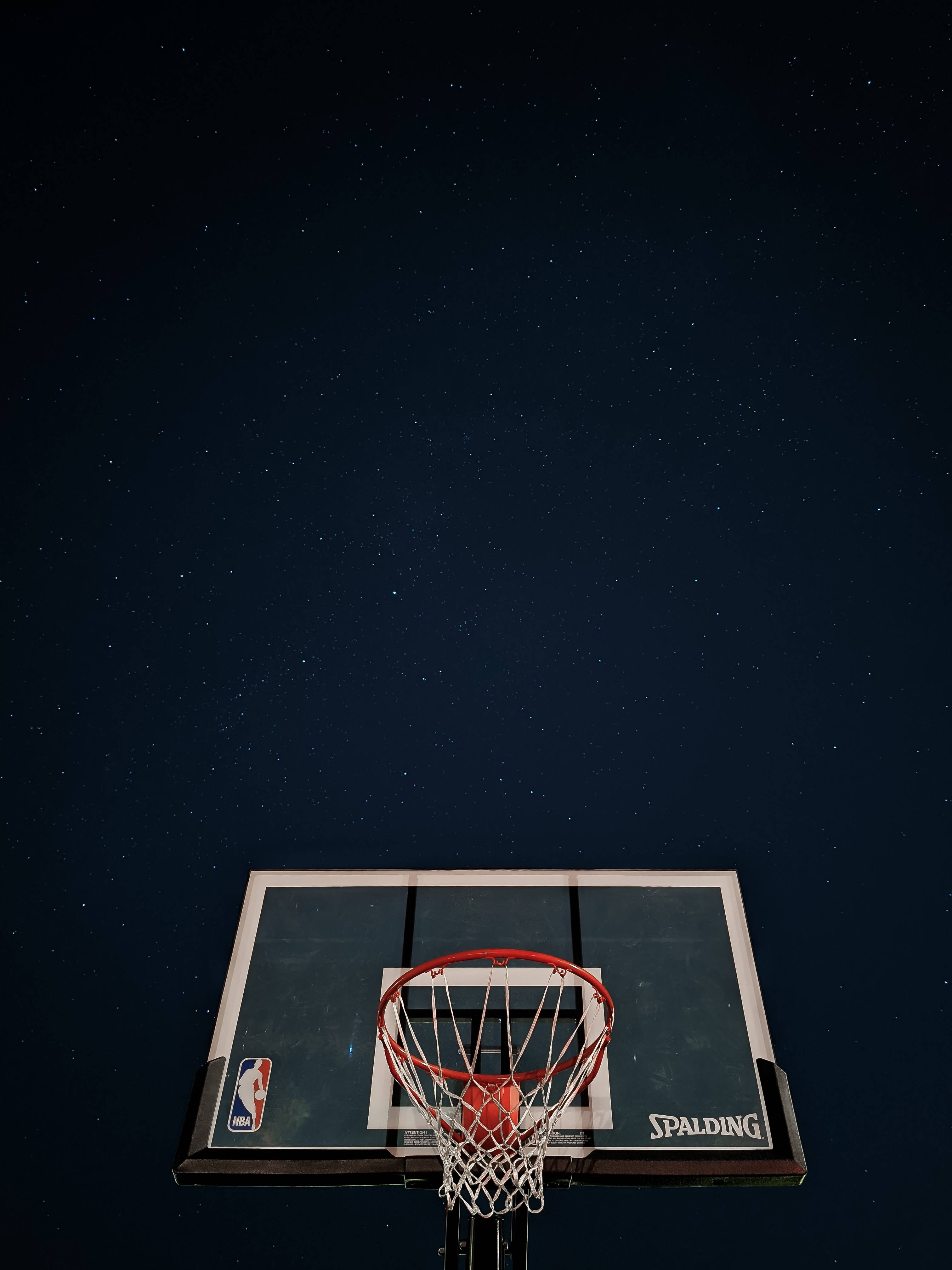 高清籃球 桌布 壁紙 — 在星空下的籃球框，帶有 Spalding 籃板和 NBA 標誌。