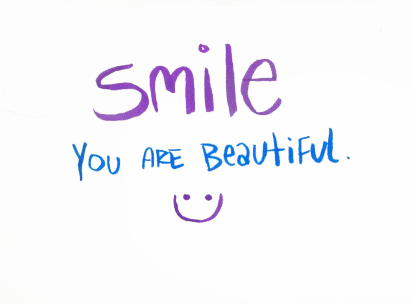You Are Beautiful 桌布 壁紙 — 在普通白紙上手寫的紫色和藍色勵志文字「微笑你很美」和笑臉。