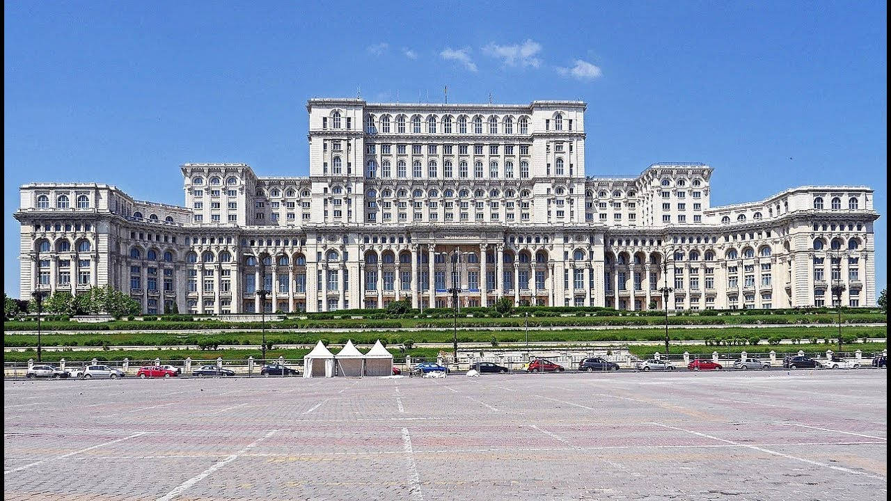 Romania 桌布 壁紙 — 在晴朗藍天下，擁有對稱翼樓和拱形窗戶的宏偉新古典主義政府建築。