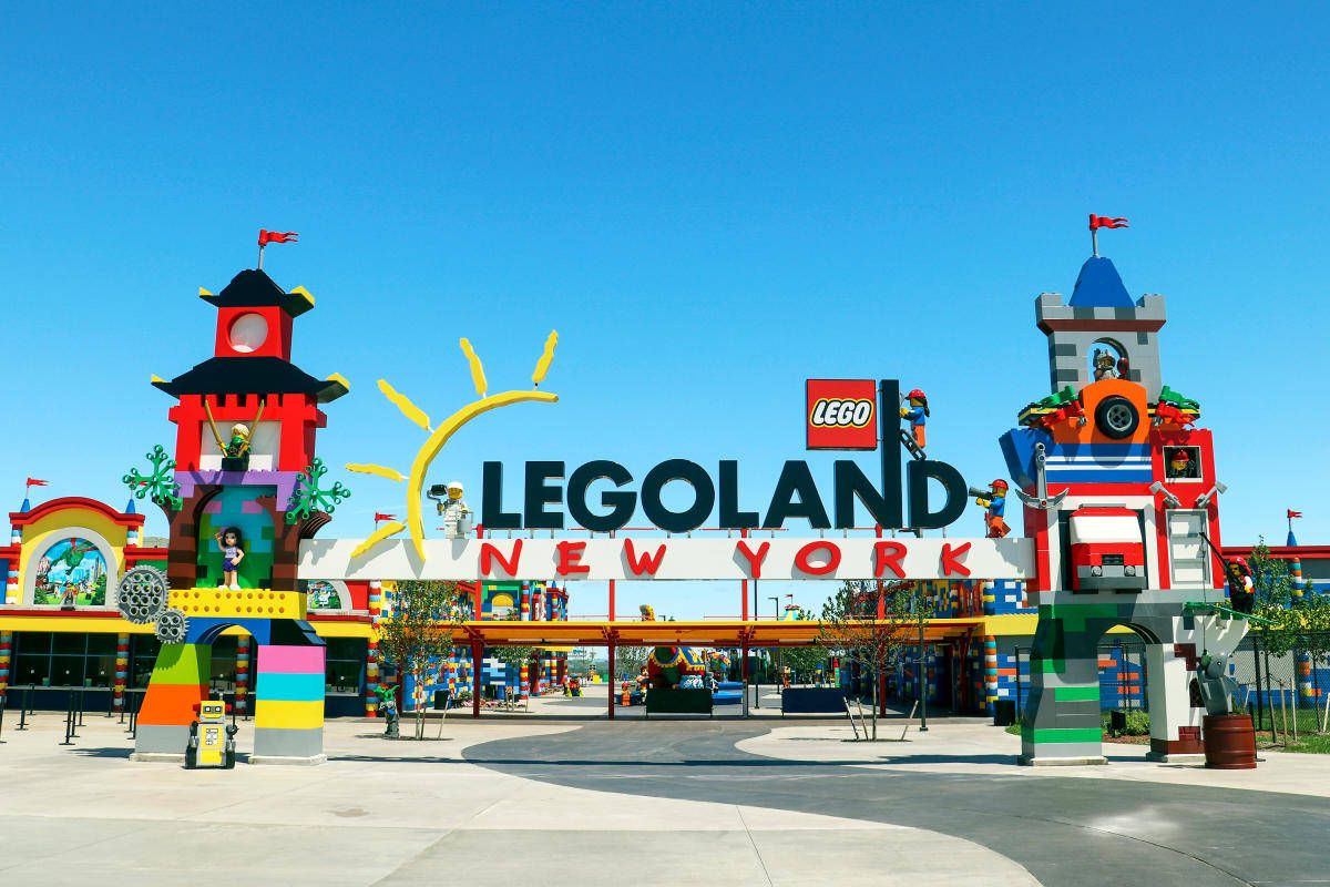 New York 桌布 壁紙 — 在晴朗藍天下，色彩繽紛的城堡式建築和大標誌的LEGOLAND New York充滿活力的LEGO主題入口。