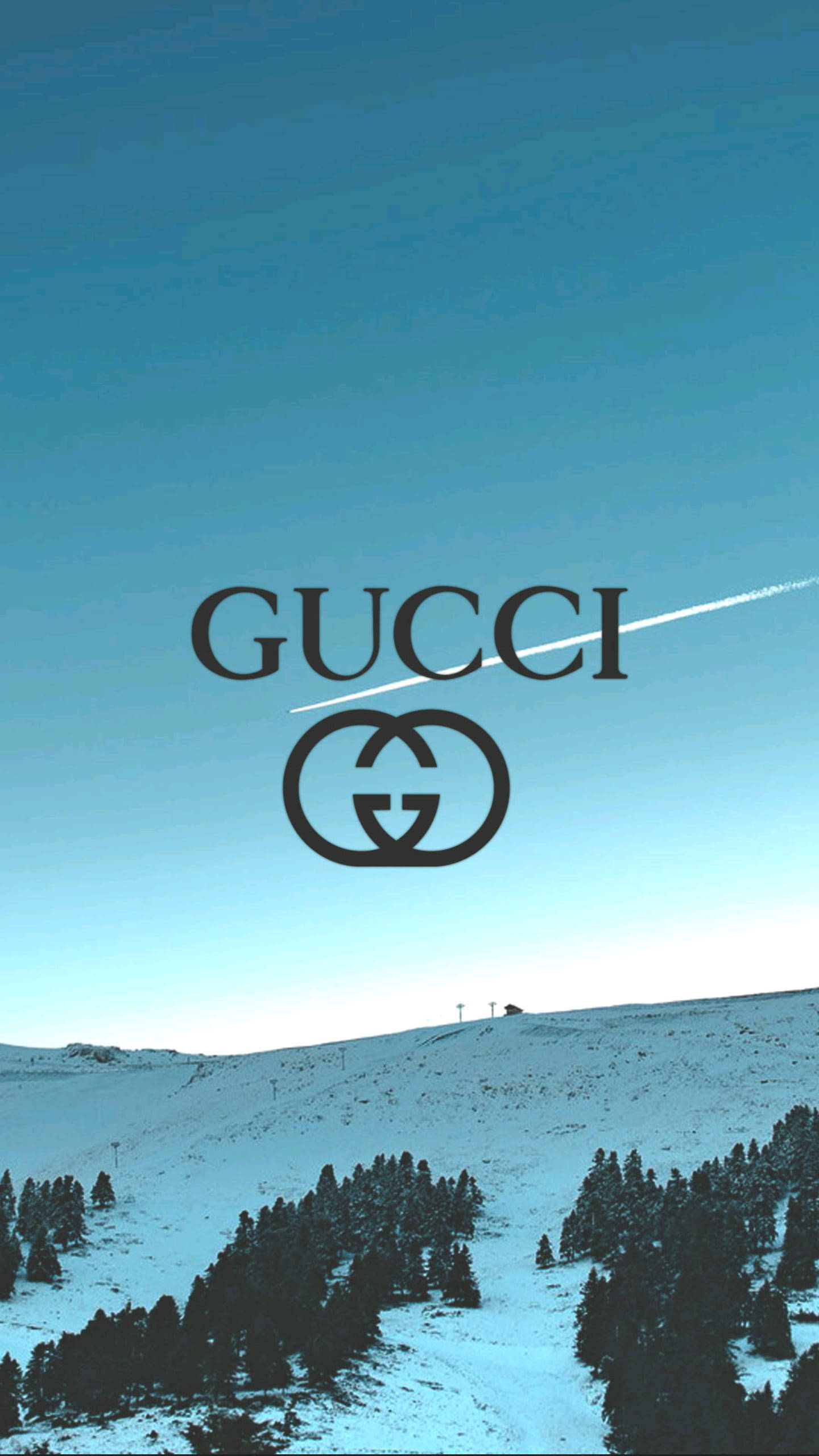 Gucci iPhone 桌布 壁紙 — 在晴朗藍天下的雪山景觀中，Gucci 標誌顯眼地置中，一條白色飛機尾跡劃過天空。
