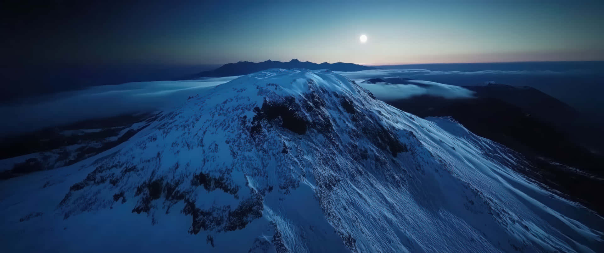 Snow-Covered Mountain Peak at Sunrise with Foggy Horizon 壁紙 — 在暮色中，一座白雪覆蓋的山峰在明亮的月光下聳立於雲海之上。