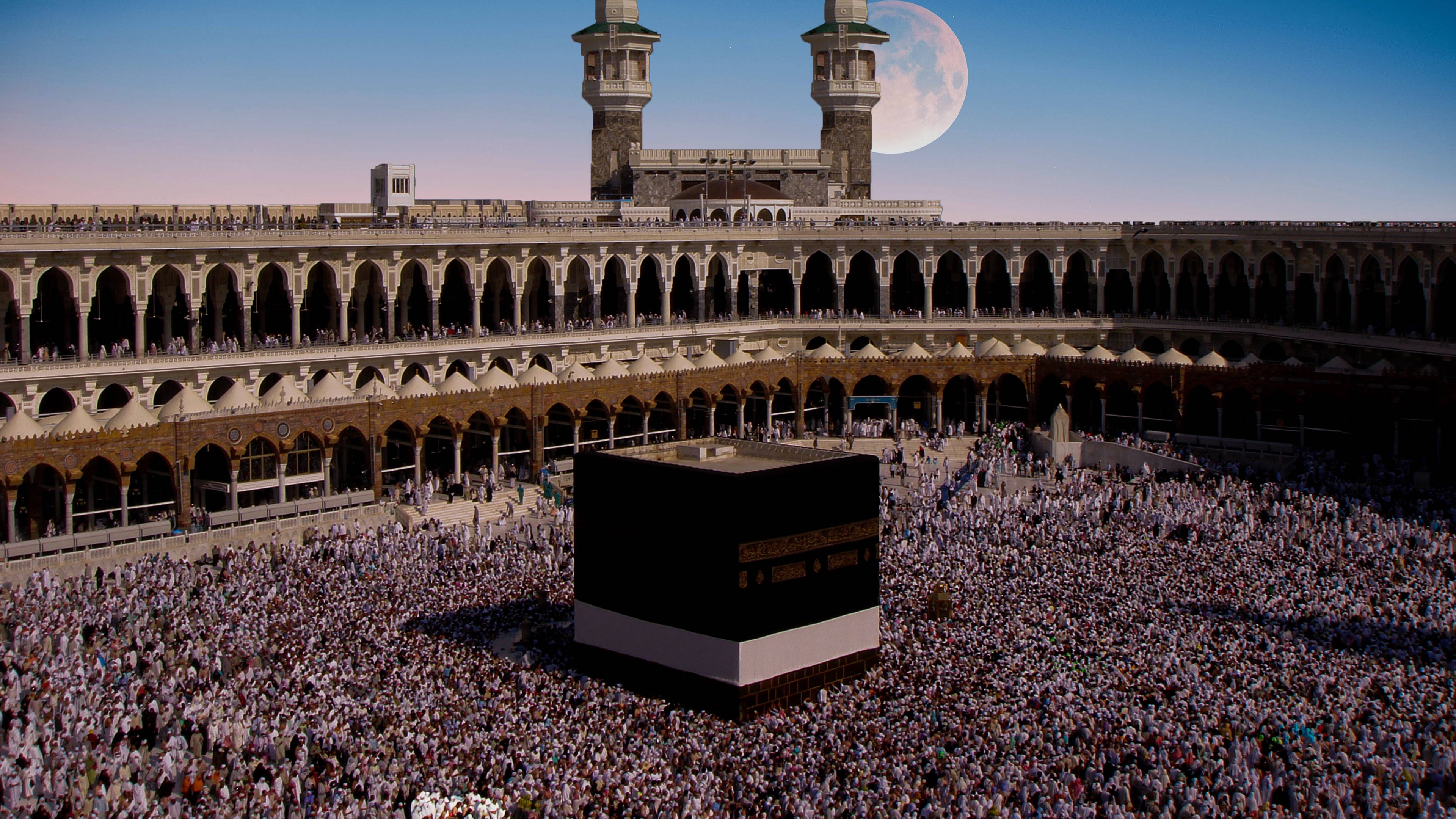 muslim 桌布 壁紙 — 在暮色天空下，巨大月亮懸掛在清真寺拱門上方，大量人群圍繞著卡巴天房。