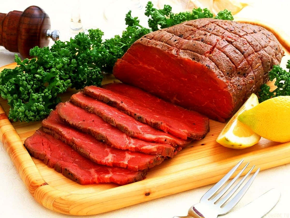 Red Meat 桌布 壁紙 — 在木砧板上切片的稀有烤牛肉，搭配新鮮歐芹和檸檬角。