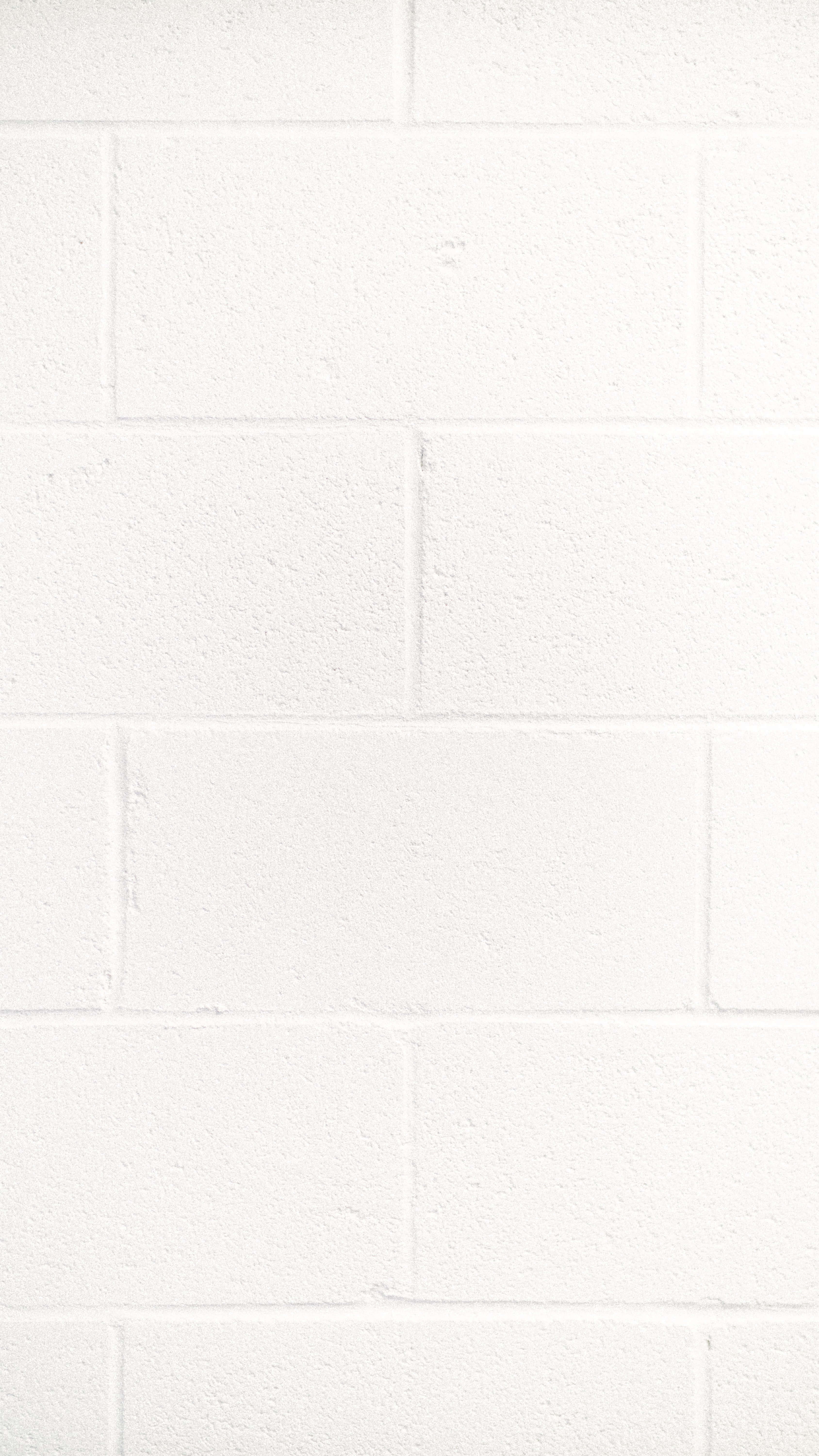 Brick Wall 桌布 壁紙 — 在柔和均勻的燈光下，一面乾淨簡約的白色磚牆，帶有細微紋理和砂漿線。