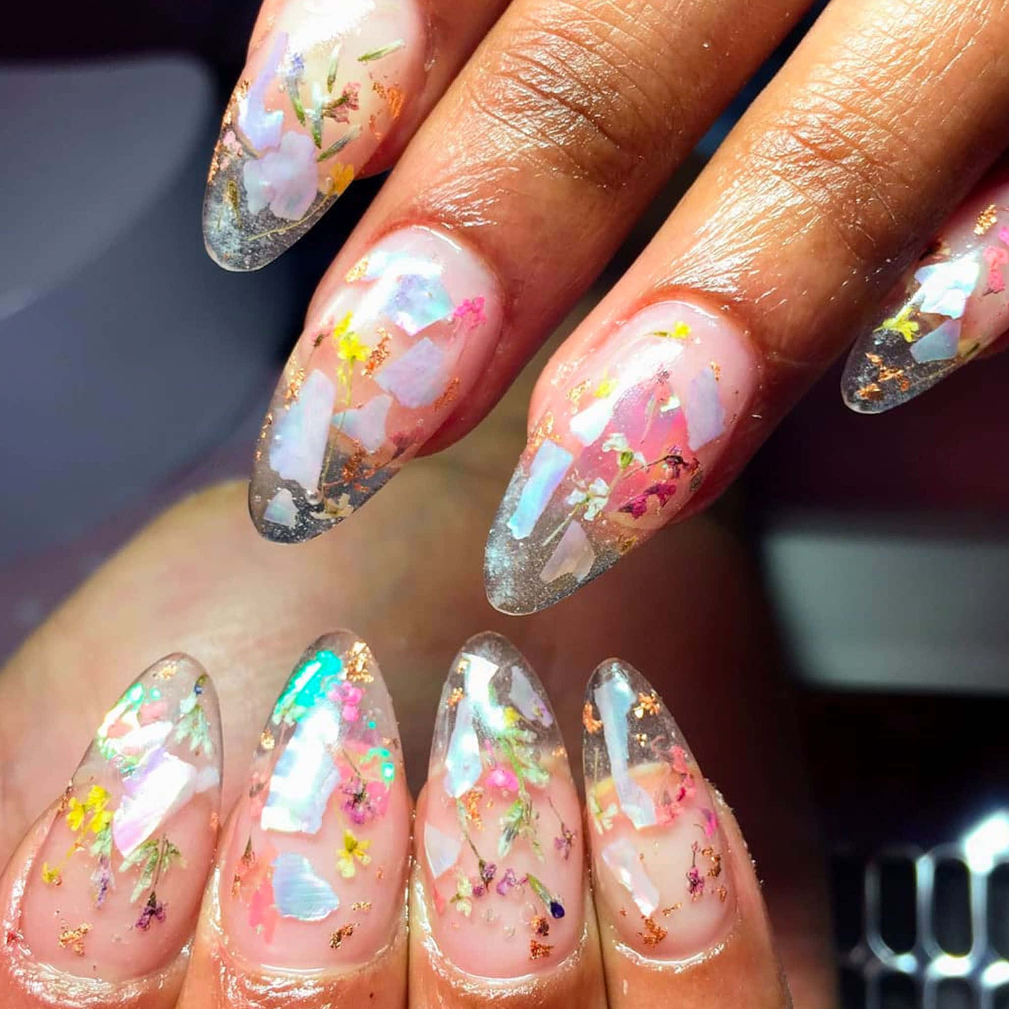 Spring Nails 桌布 壁紙 — 在柔和燈光下，優雅的長指甲飾以精緻的壓花、虹彩閃片和金色亮粉。