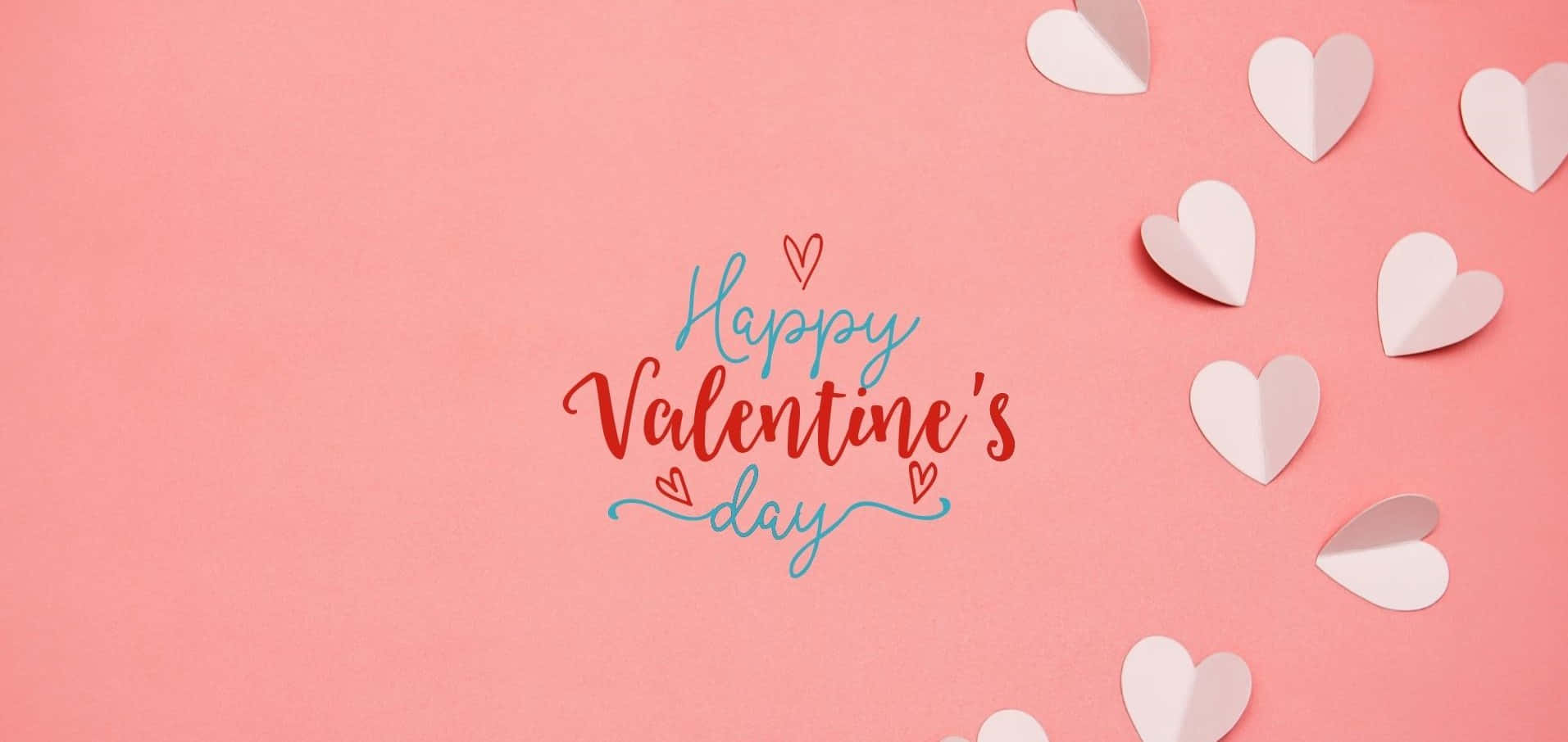 High Resolution Valentines Day 桌布 壁紙 — 在柔和的粉紅色背景上，以紅色和藍色字體書寫的「Happy Valentine's Day」文字，並散落著白色紙心。
