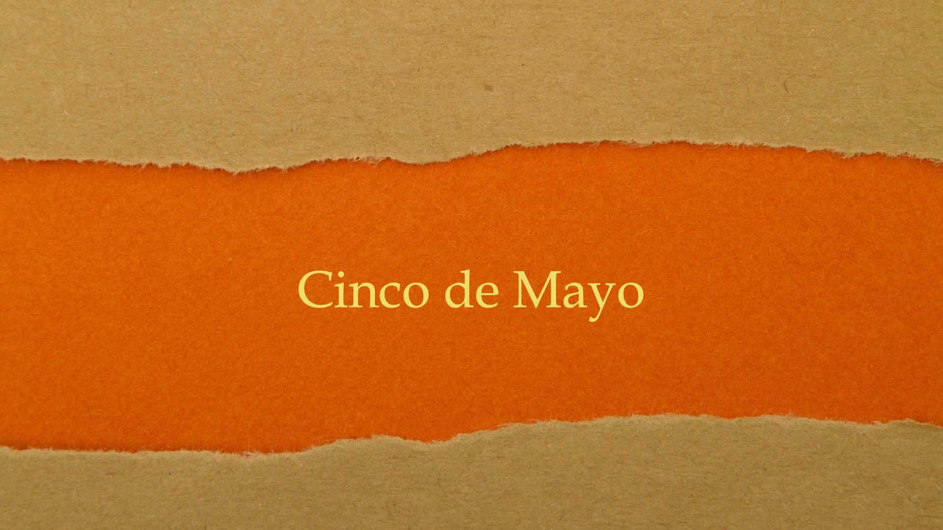 Cinco De Mayo 桌布 壁紙 — 在棕色牛皮紙背景上，一條撕破的橙色紙條上以金色字母寫著 Cinco de Mayo 的文字。