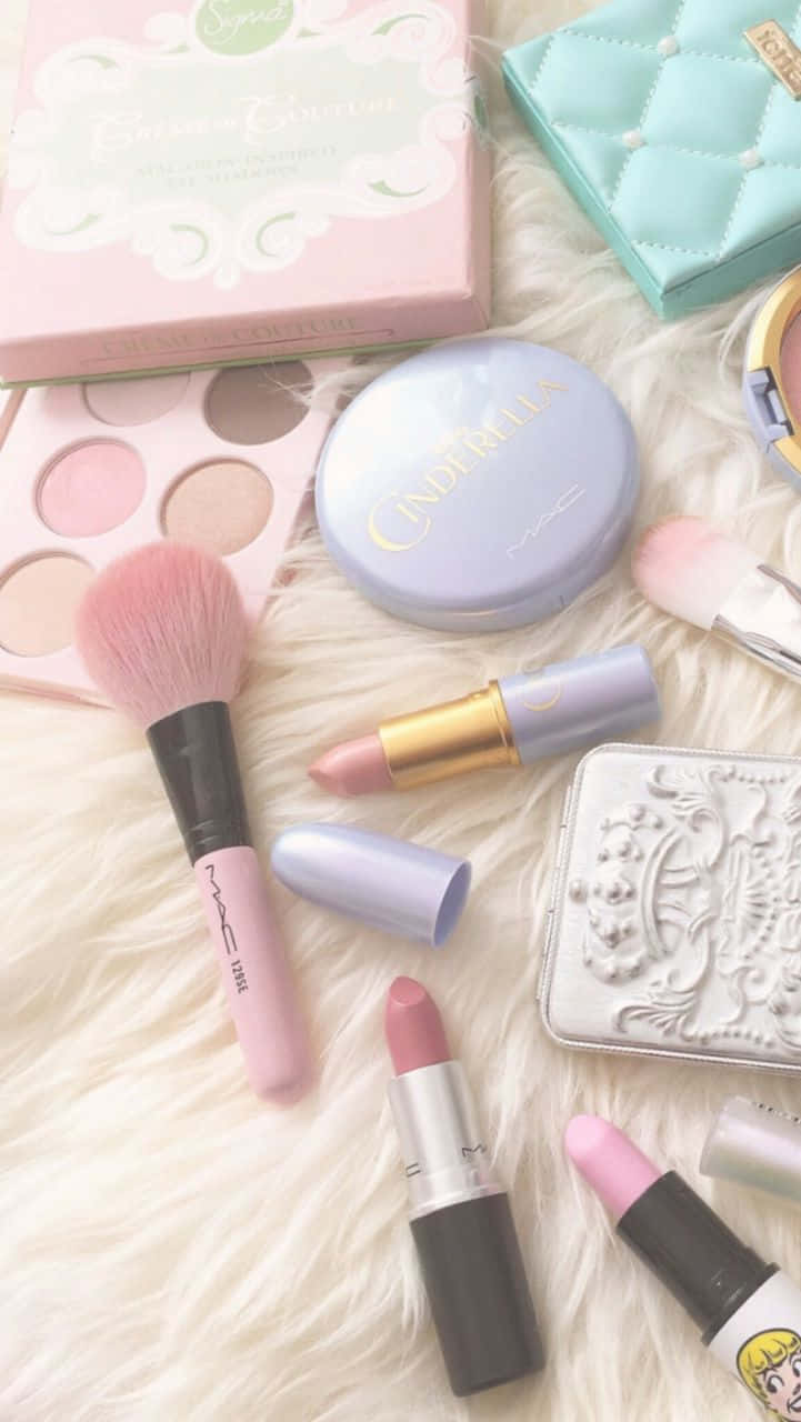 Cute Makeup 桌布 壁紙 — 在毛絨白色表面上平鋪擺放粉彩化妝品，包括唇膏、刷子和眼影盤。