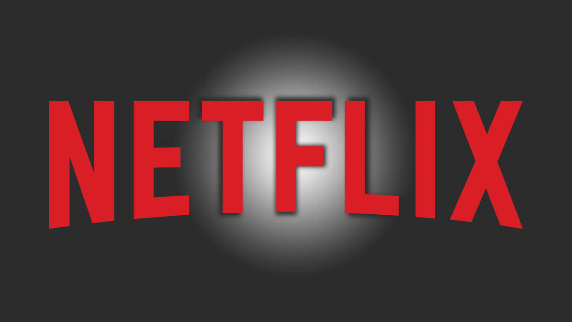 黑白 桌布 壁紙 — 在深灰色背景上，聚光燈下居中放置的醒目紅色Netflix標誌。
