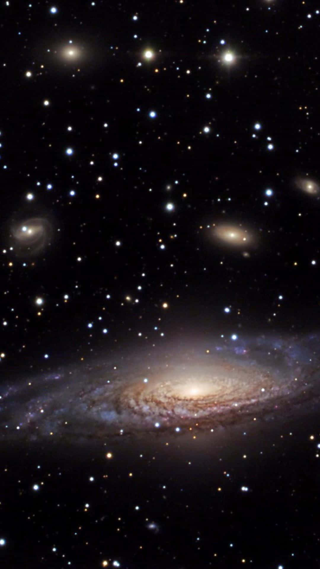 3d Galaxy 桌布 壁紙 — 在深空中，一個螺旋星系散發著金色和藍色光芒，被無數恆星環繞的壯麗景象。