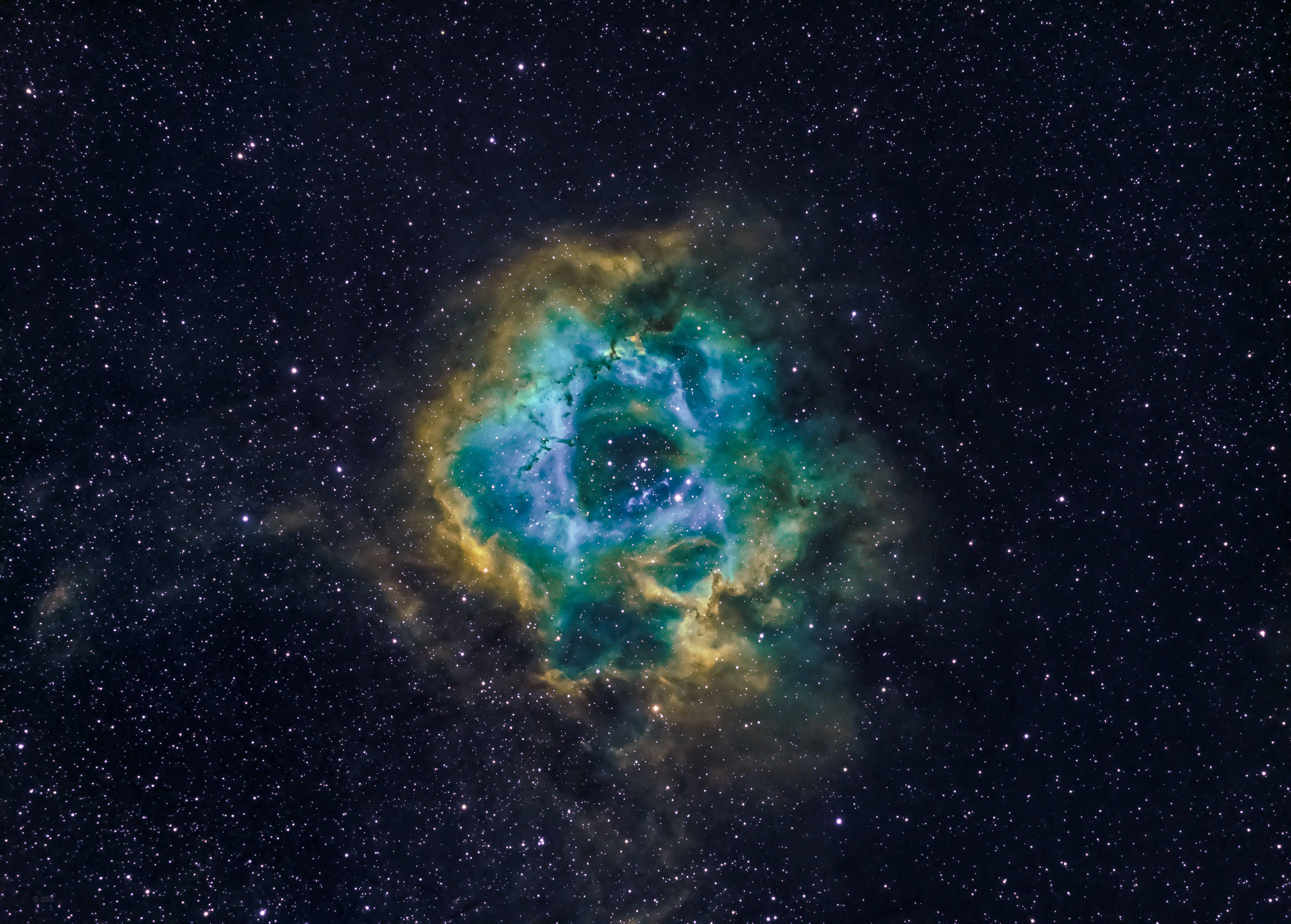 宇宙美學 桌布 壁紙 — 在深空星場背景下，散發著青綠色和金色光芒的充滿活力的宇宙星雲。