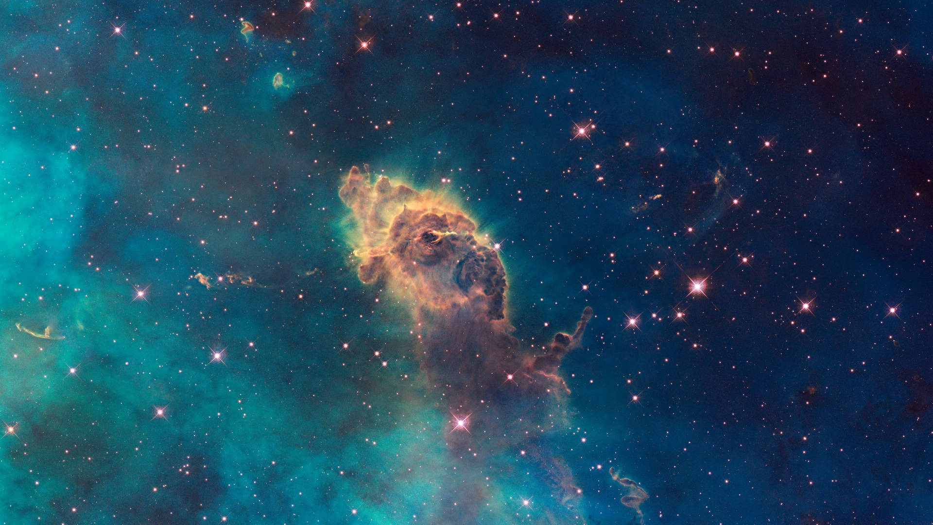 宇宙美學 桌布 壁紙 — 在深空的星場背景下，一個充滿活力的宇宙星雲散發著青綠色和琥珀色的光芒。