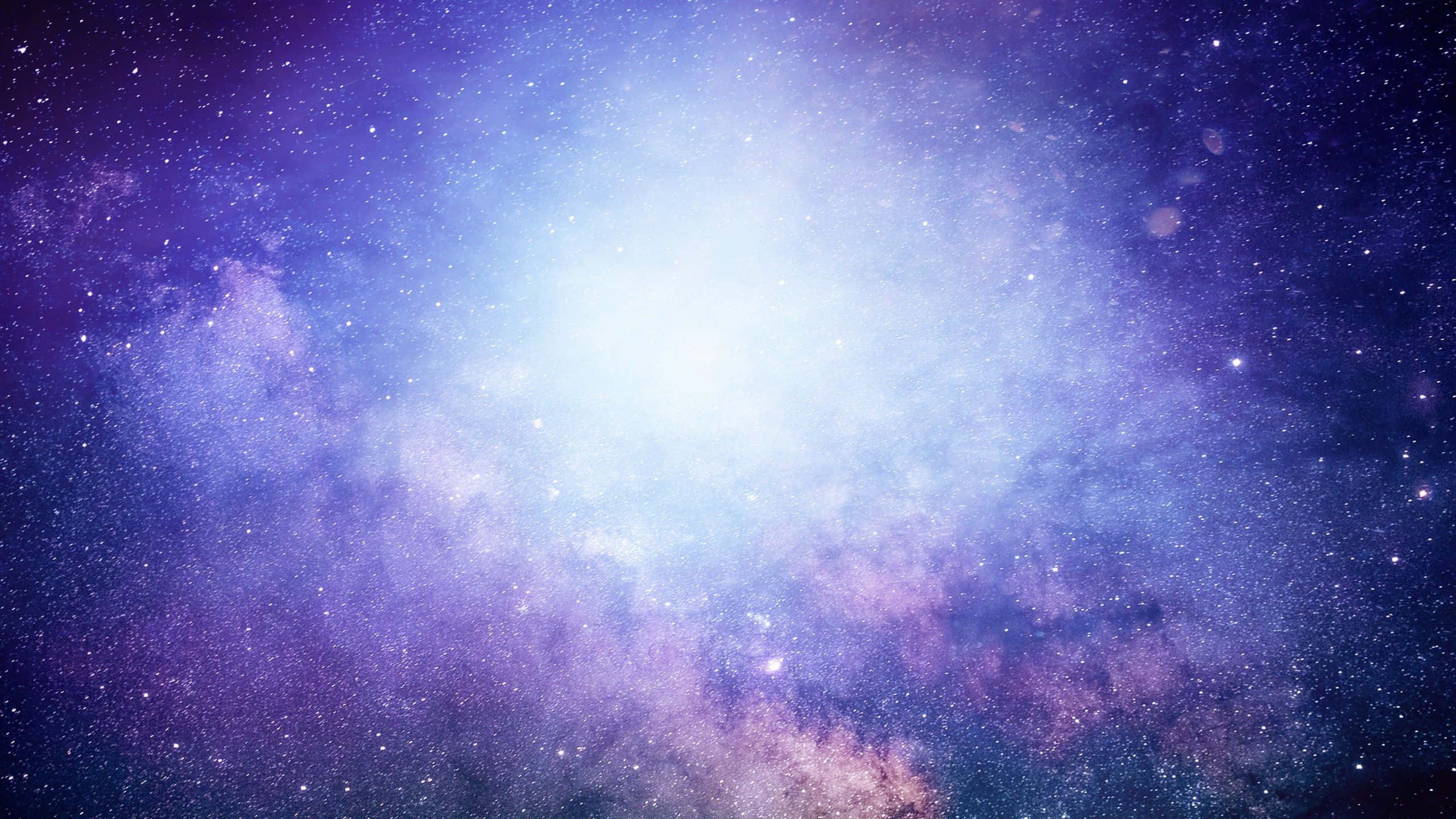 Galaxy Stars 桌布 壁紙 — 在深空的星場背景下，一團輻射宇宙星雲散發著紫色和藍色的光芒。