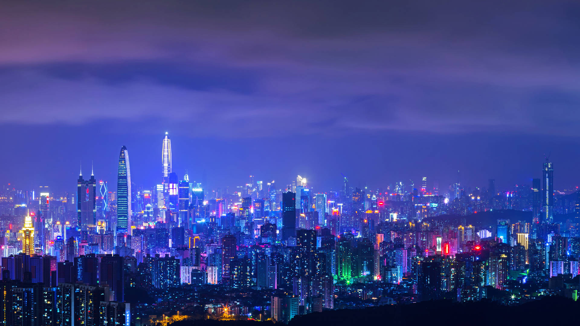 Shenzhen 桌布 壁紙 — 在深紫色天空下，廣闊的城市天際線被鮮豔的霓虹燈照亮。