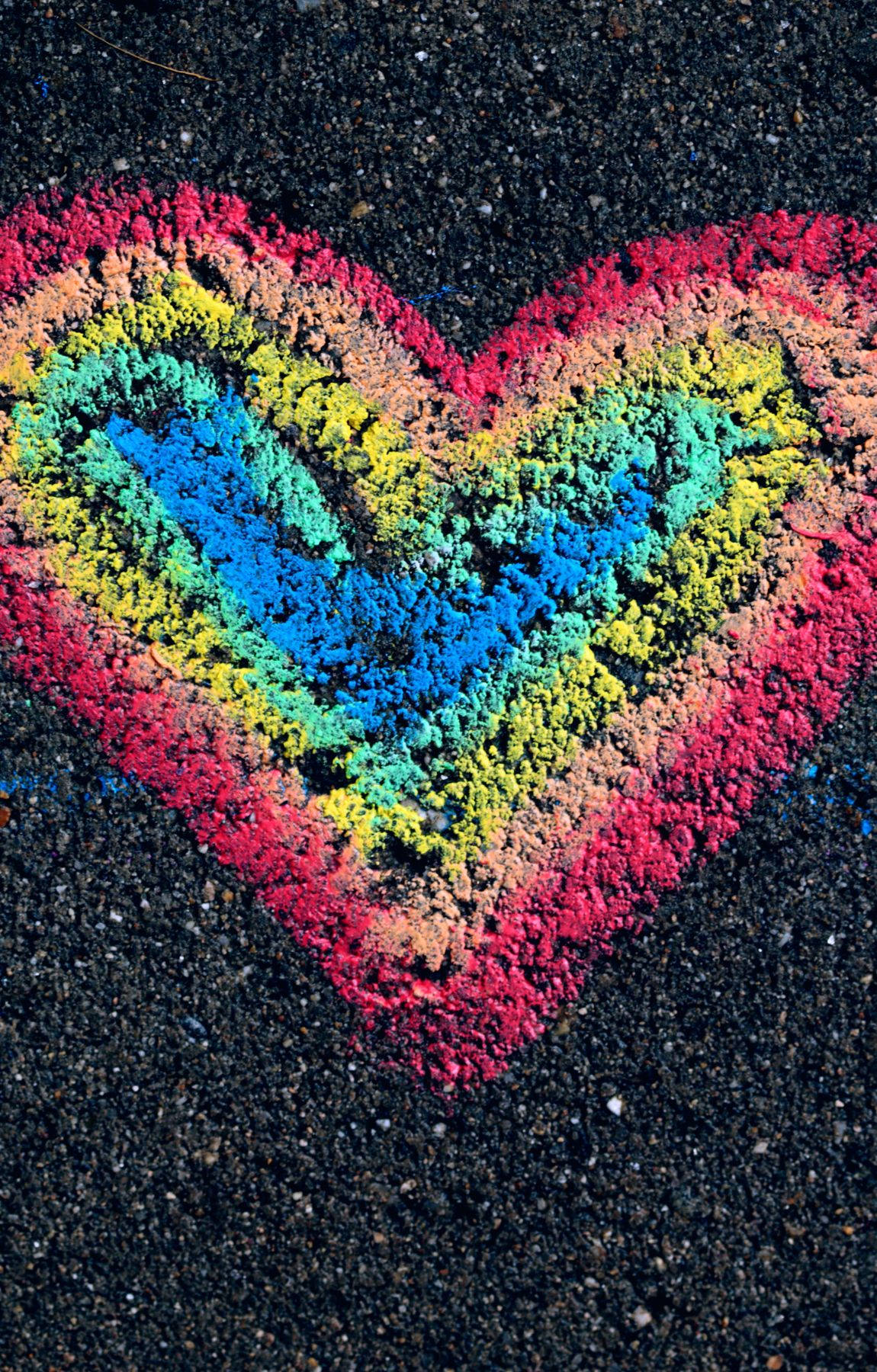 Subtle Lgbt 桌布 壁紙 — 在深色瀝青上用粉筆繪製的充滿活力的彩虹心，展現出紋理豐富、色彩繽紛且俏皮的街頭藝術作品。