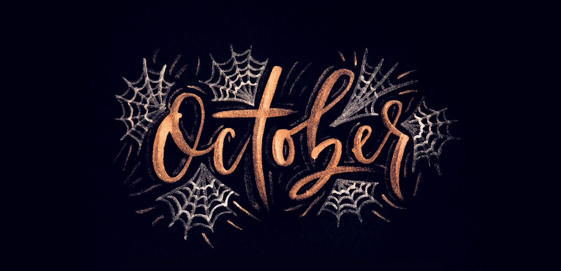 October 桌布 壁紙 — 在深色背景上，閃閃發光的銅色字體寫著「October」，周圍環繞著銀色蜘蛛網。