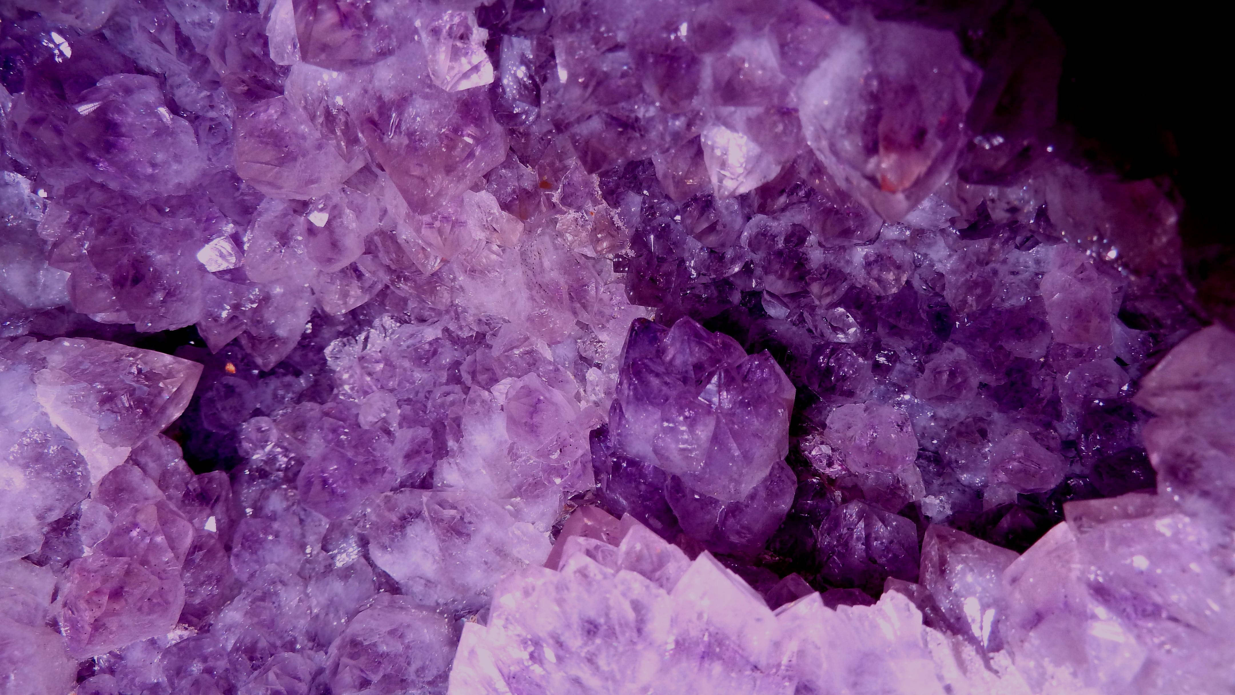 Amethyst 桌布 壁紙 — 在深色背景下，閃閃發光的紫色紫水晶晶體散發著濃郁的紫羅蘭色調的特寫。