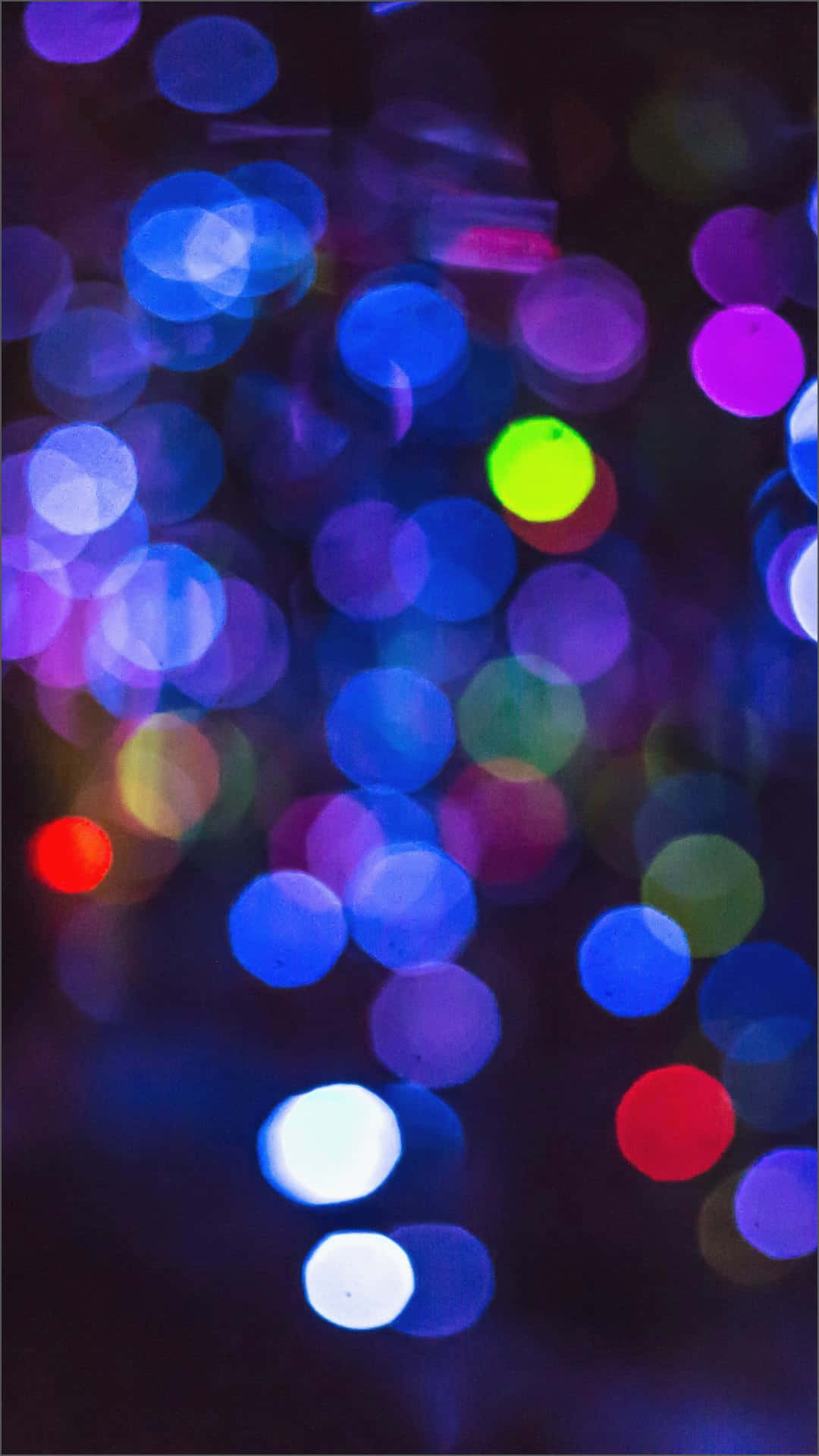 iPhone Neon 桌布 壁紙 — 在深藍色、紫色以及紅色、綠色和白色點綴的暗色背景下，呈現出模糊城市燈光的鮮明散景效果。