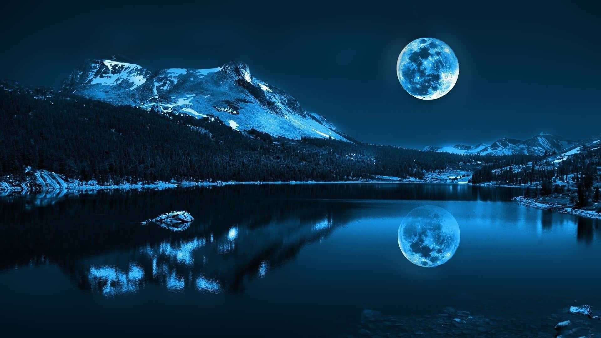 Midnight 桌布 壁紙 — 在深藍色夜空下，寧靜的月光湖面倒映著巨大的發光月亮和積雪覆蓋的山脈。