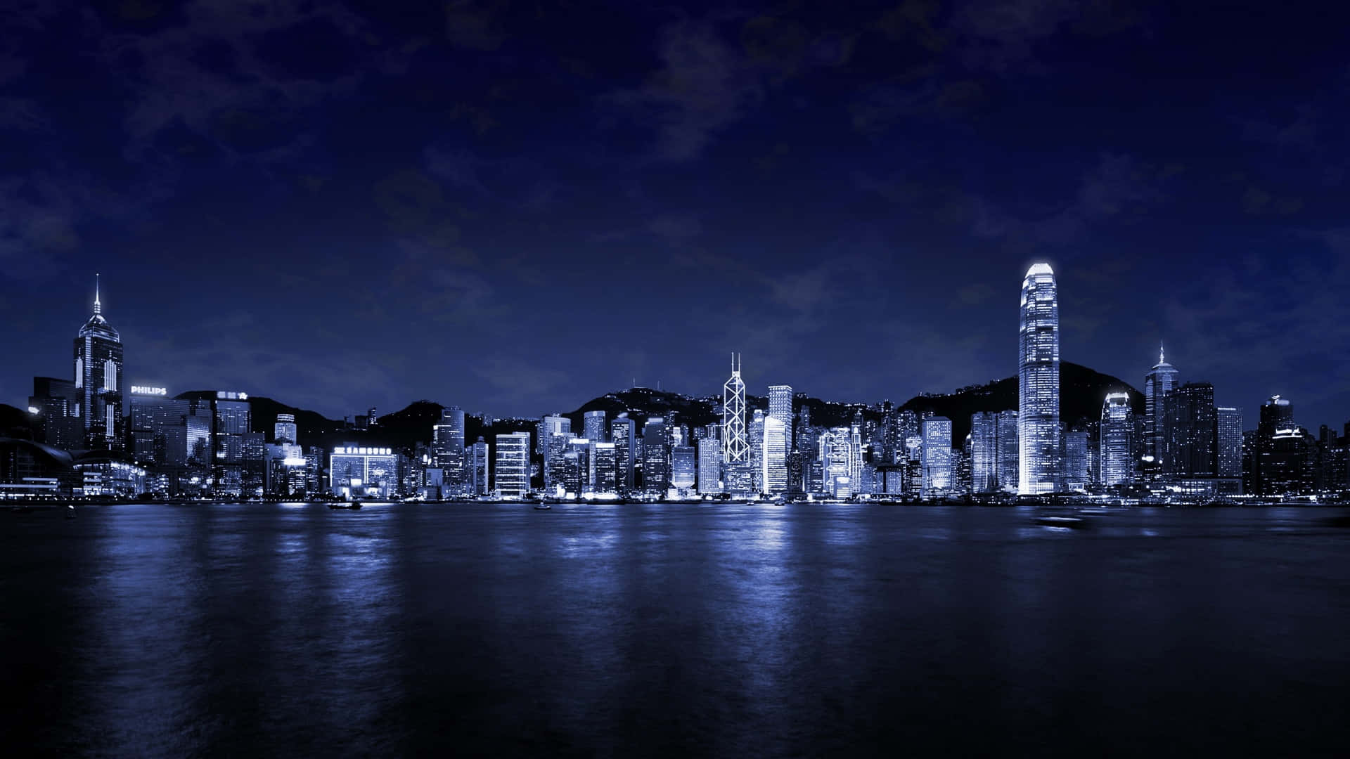 City Night 桌布 壁紙 — 在深藍色天空下，香港璀璨的天際線倒映在平靜水面上，令人驚嘆的夜景。