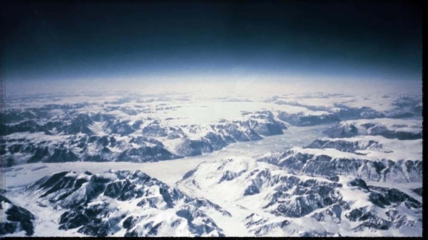 Greenland 桌布 壁紙 — 在深藍色天空和大氣薄霧下，無盡的雪山和冰川的鳥瞰圖。
