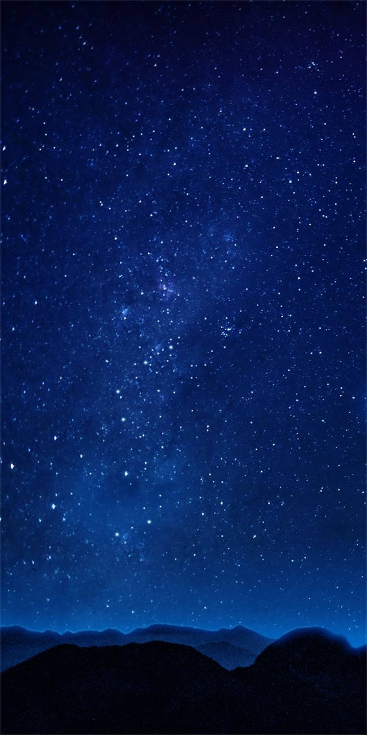 alcatel 桌布 壁紙 — 在深藍色調下，黑暗山脈輪廓上方佈滿星星的夜空，令人嘆為觀止。