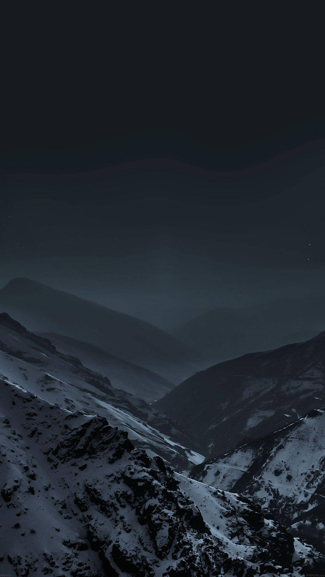 雪山 桌布 壁紙 — 在深邃夜空下，一個嚴酷的冬季山谷，有微弱的星星和霧氣層層疊疊的山峰。
