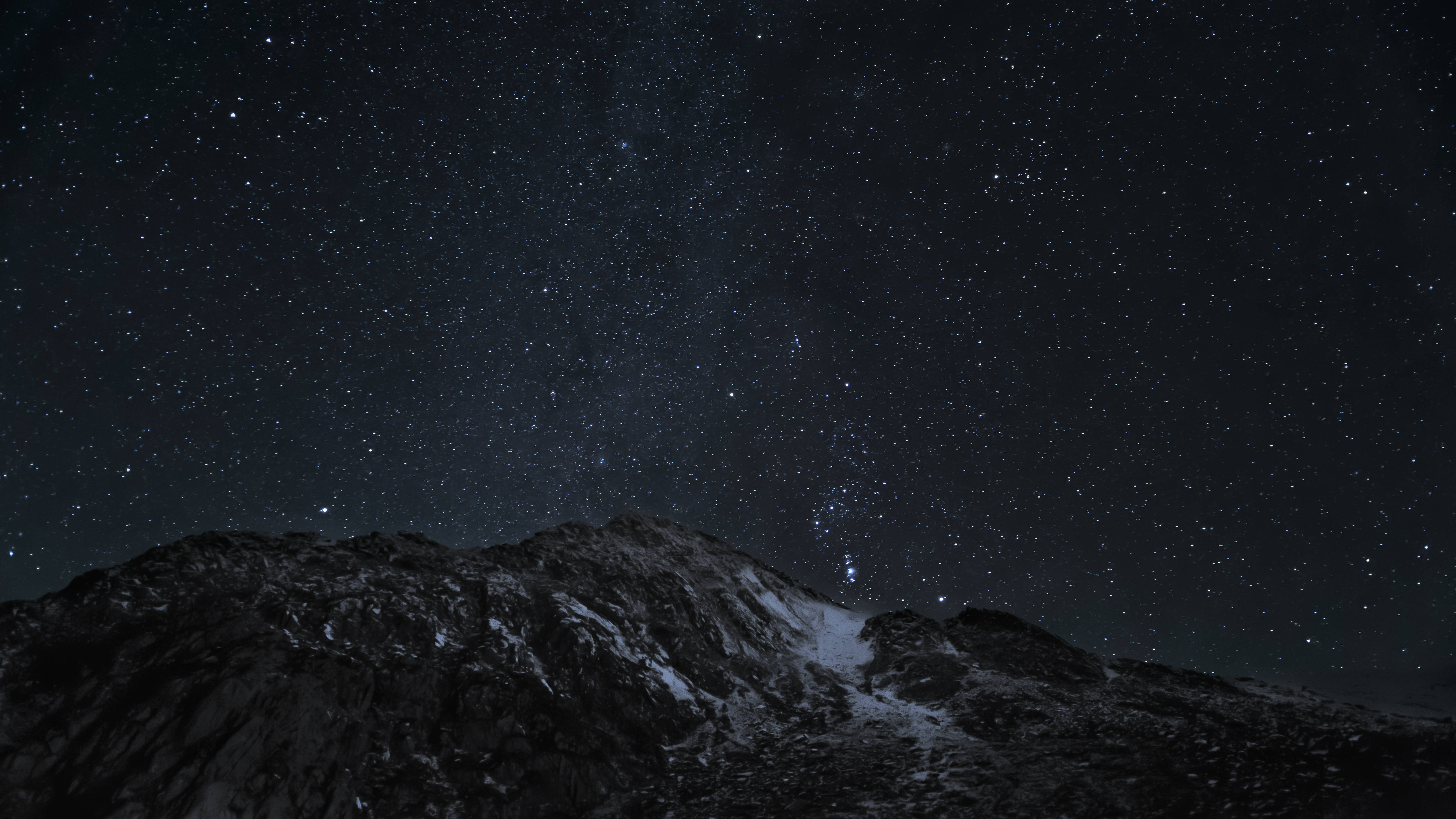 夜空 桌布 壁紙 — 在深邃夜空下，被白雪覆蓋的山脊在密集星幕中呈現剪影。