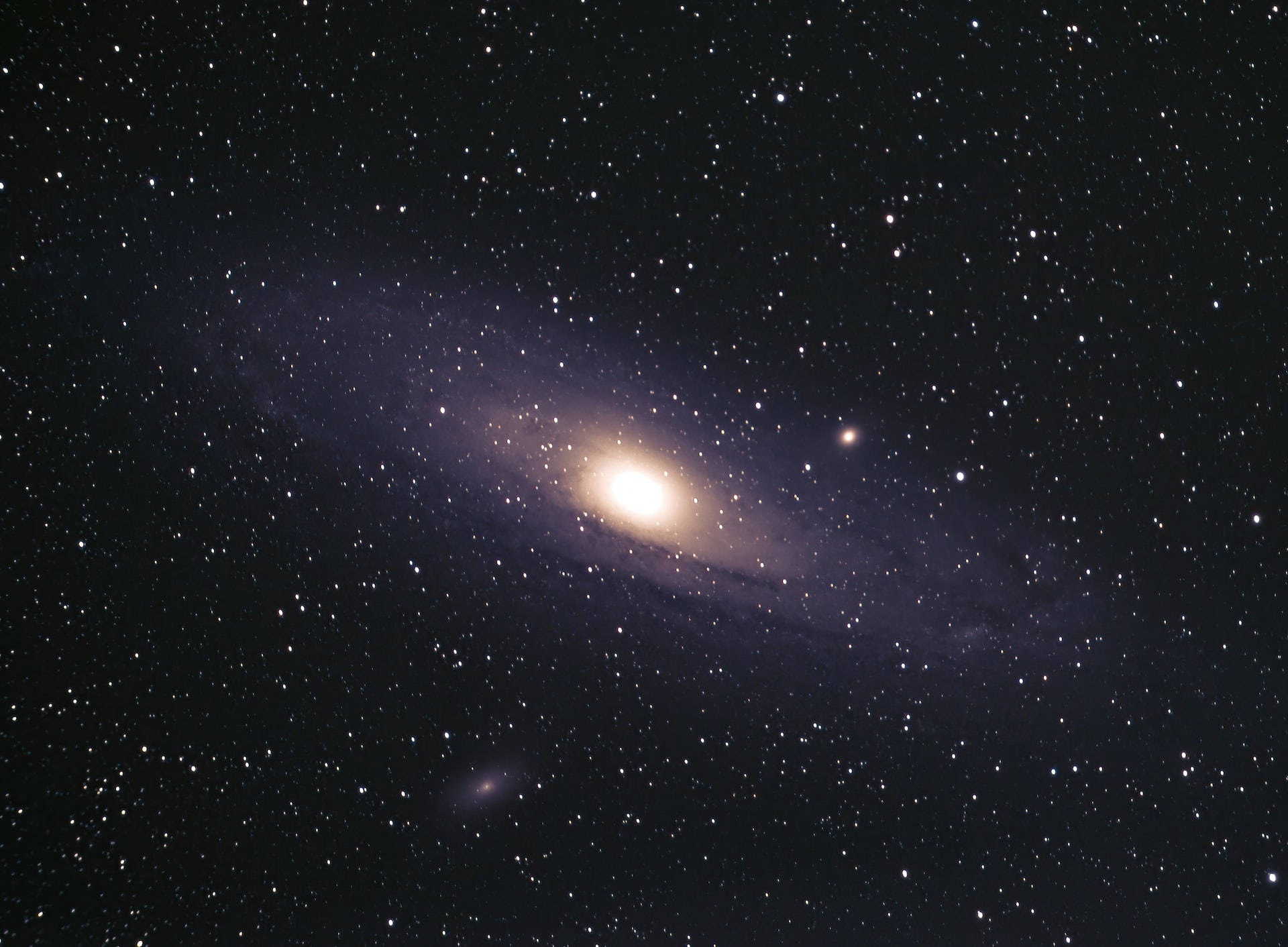 Stars 桌布 壁紙 — 在深邃漆黑的夜空下，一顆明亮的螺旋星系在繁星點點的宇宙廣袤中心閃耀。