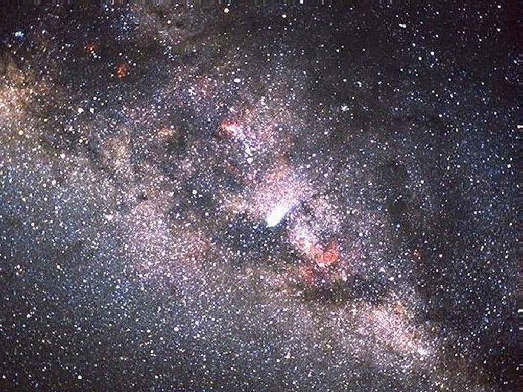 銀河 桌布 壁紙 — 在深邃的宇宙背景下，銀河系與恆星、塵埃雲和發光星雲旋轉的壯麗景色。