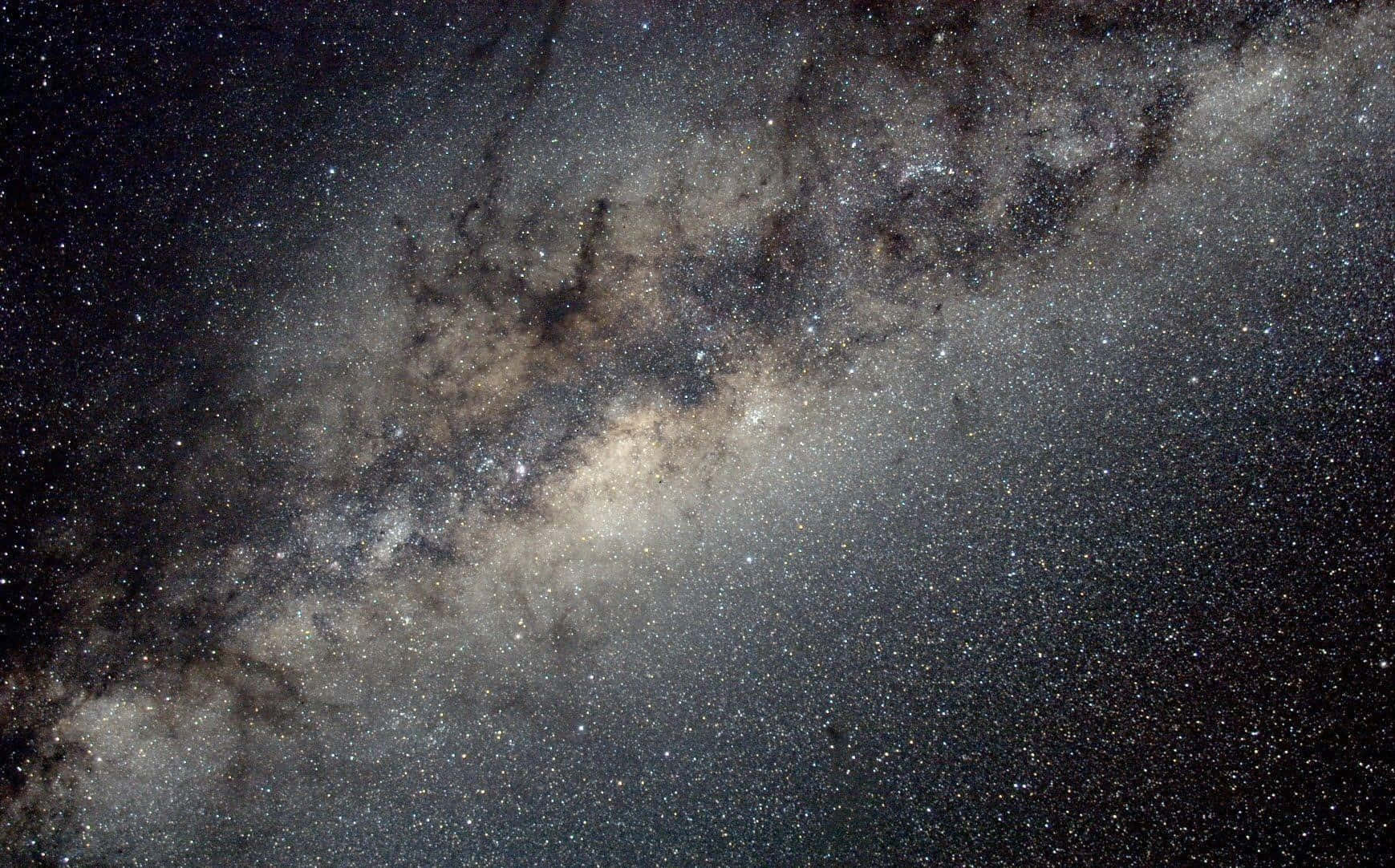 銀河 桌布 壁紙 — 在深邃的黑色天空中，銀河系與星星、塵埃雲和宇宙塵埃旋轉的壯麗景色。