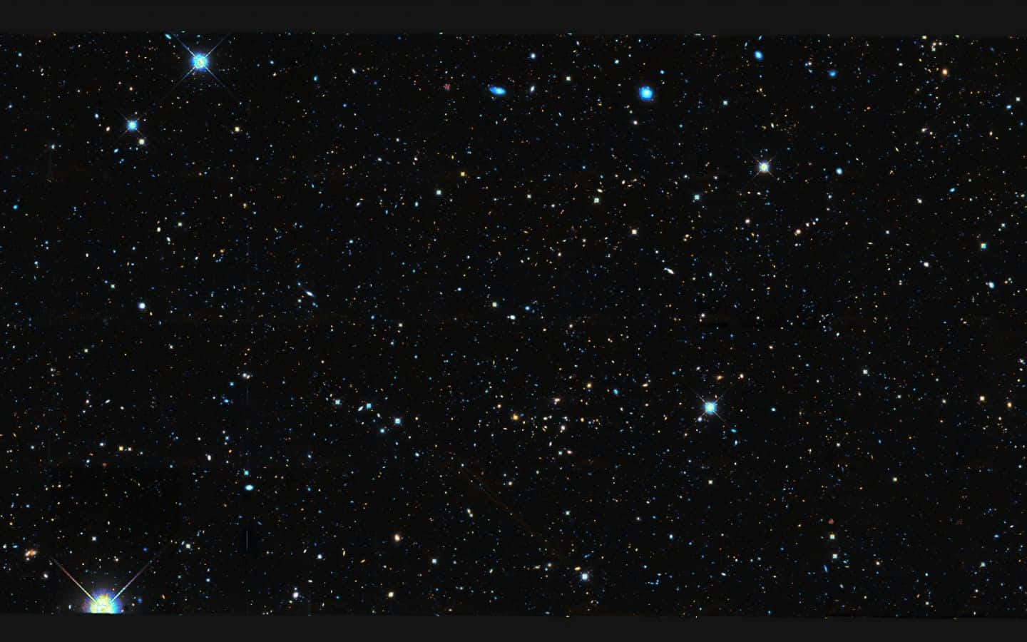 Black Galaxy 桌布 壁紙 — 在深邃的黑色宇宙背景下，無數閃爍的星星和幾顆明亮的藍色星星構成了令人嘆為觀止的星空景觀。