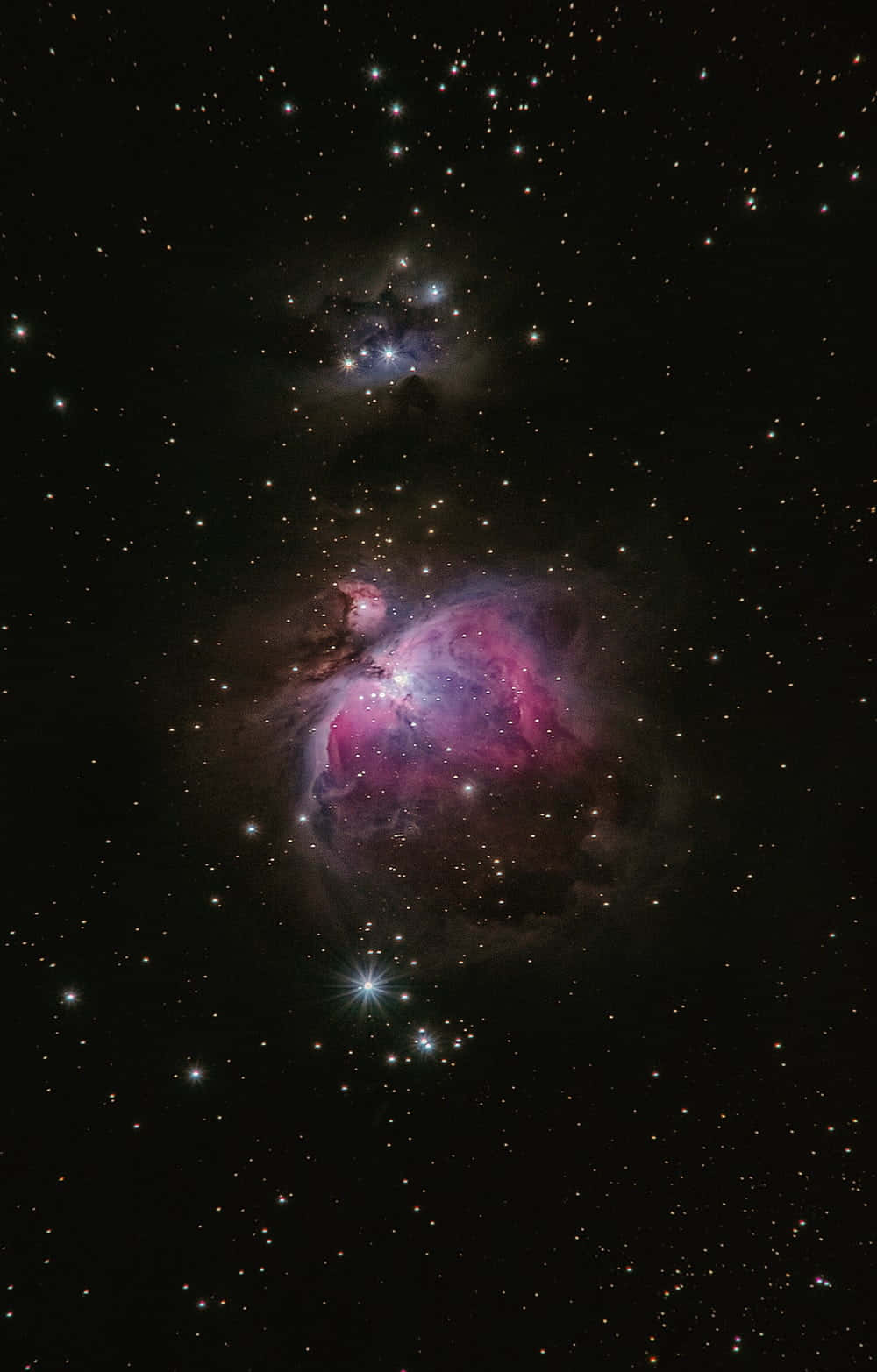 Real Galaxy 桌布 壁紙 — 在深邃的黑色宇宙虛空中，一片充滿活力的粉紅色和紫色星雲在星場中發光。