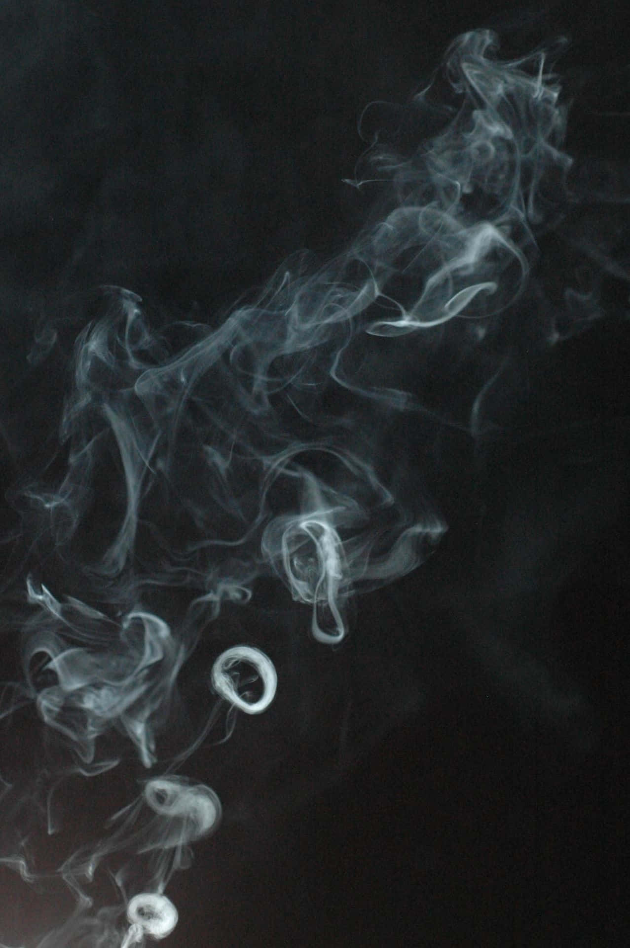 桌布 壁紙 — 在深邃的黑色背景上，飄渺的白色煙霧旋轉纏繞，形成幽靈般的抽象動感。