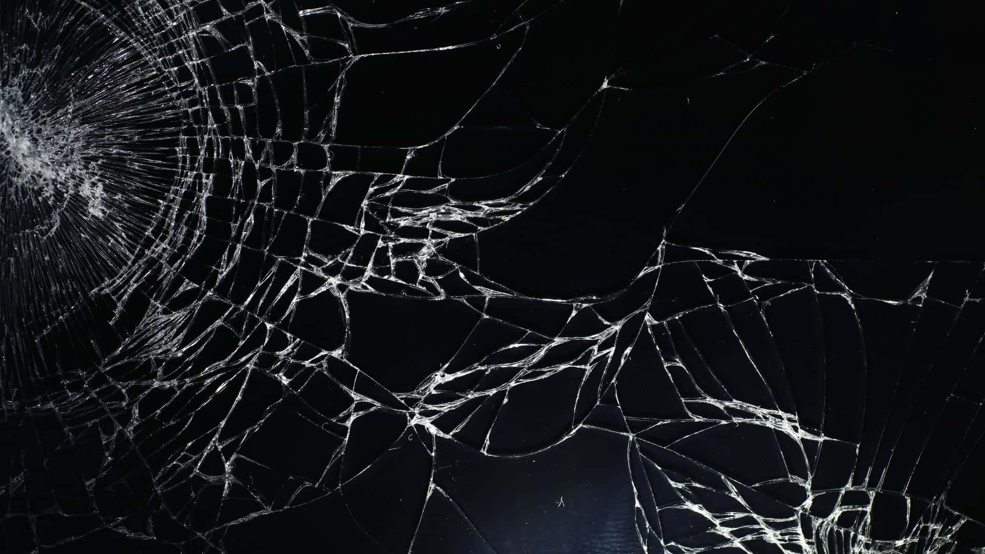 碎屏 桌布 壁紙 — 在深黑色背景上，帶有複雜白色裂紋的破碎玻璃表面。