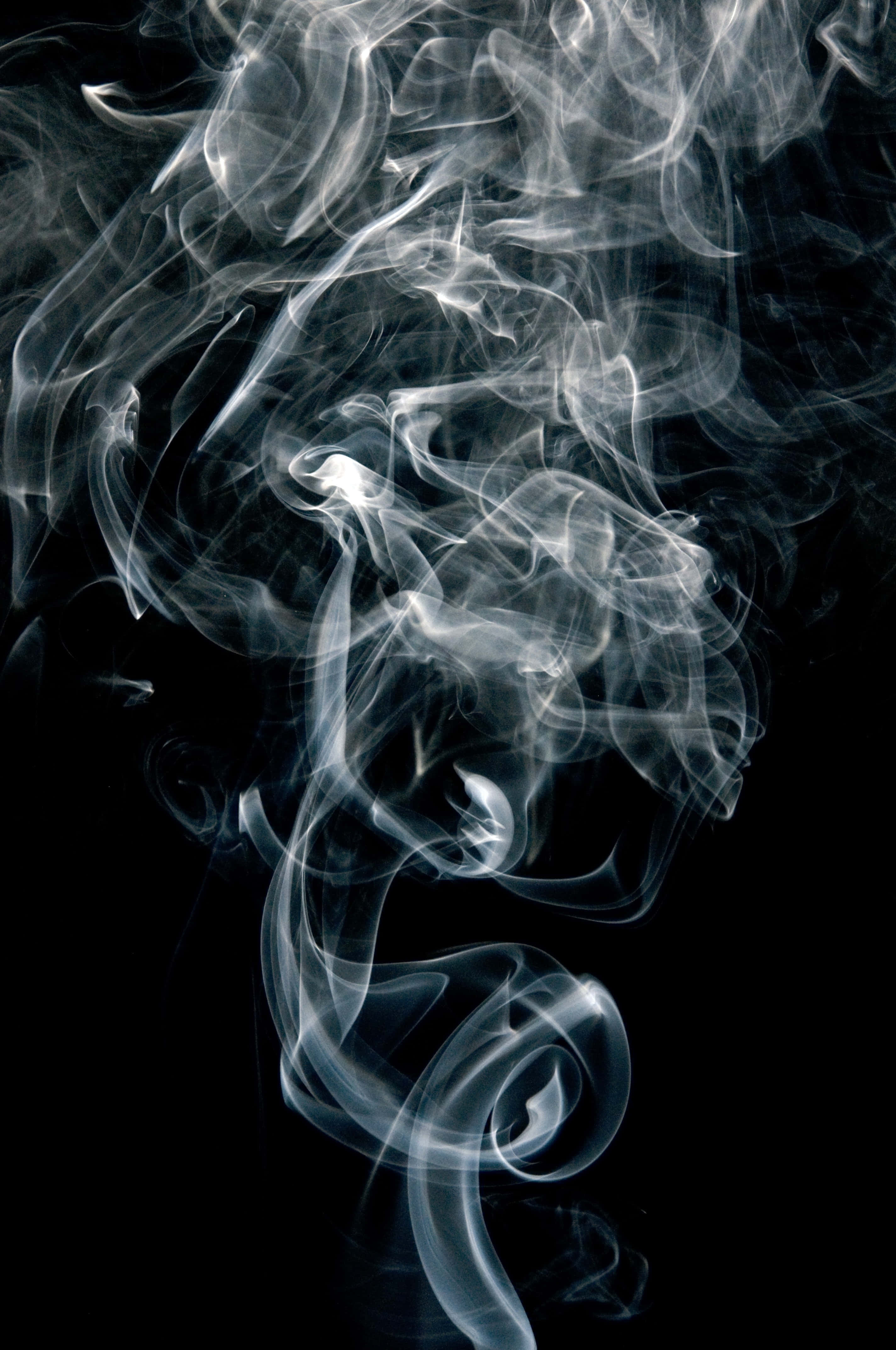 White Smoke 桌布 壁紙 — 在深黑色背景上，飄渺的白色煙霧旋轉纏繞，形成動態抽象圖案。